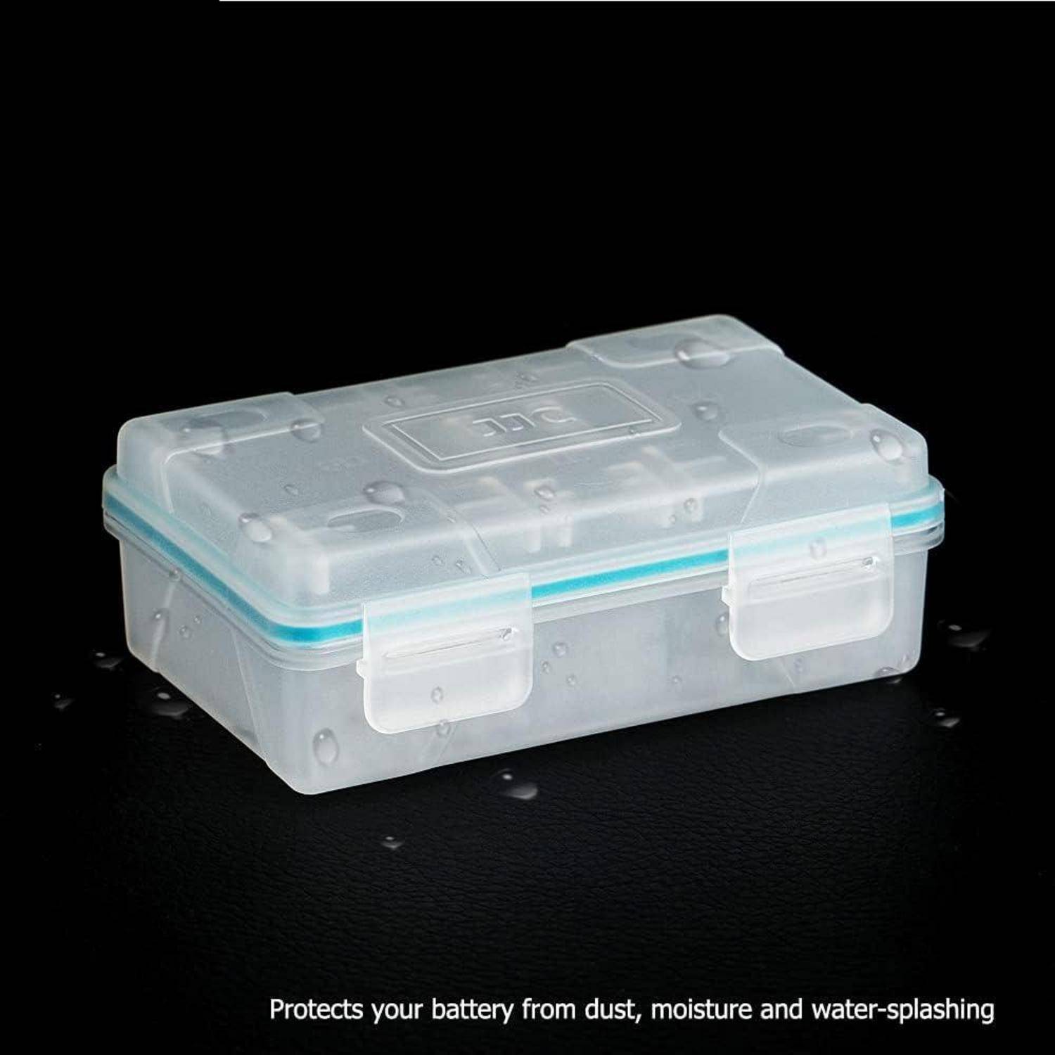 Eine transparente Plastikbox mit einem versiegelten Deckel liegt auf einer nassen Oberfläche, mit der Bildunterschrift „Schützt Ihre Batterie vor Staub, Feuchtigkeit und Wassersprittern