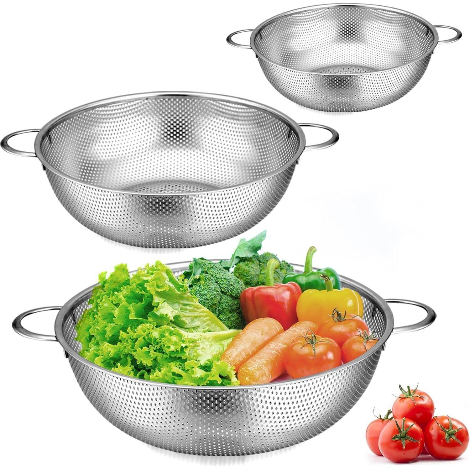Satz Edelstahl-Siebe, zwei leer, einer gefüllt mit frischem Gemüse, darunter Salat, Brokkoli, Karotten, Paprika und Tomaten.