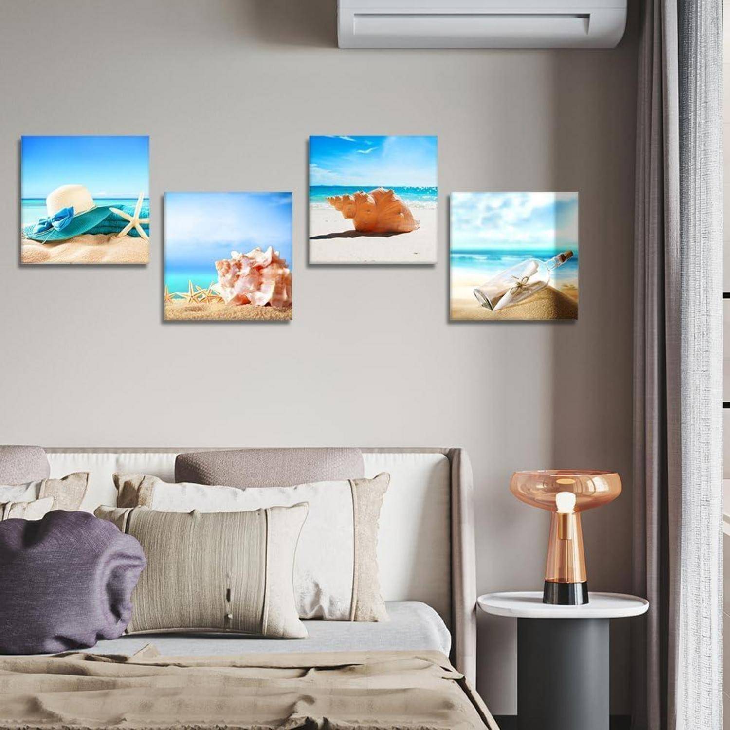 Gemälde von Strandszenen hängen über einem Sofa in einem Wohnzimmer mit schlichter Einrichtung und vermitteln eine entspannte Küstenatmosphäre.