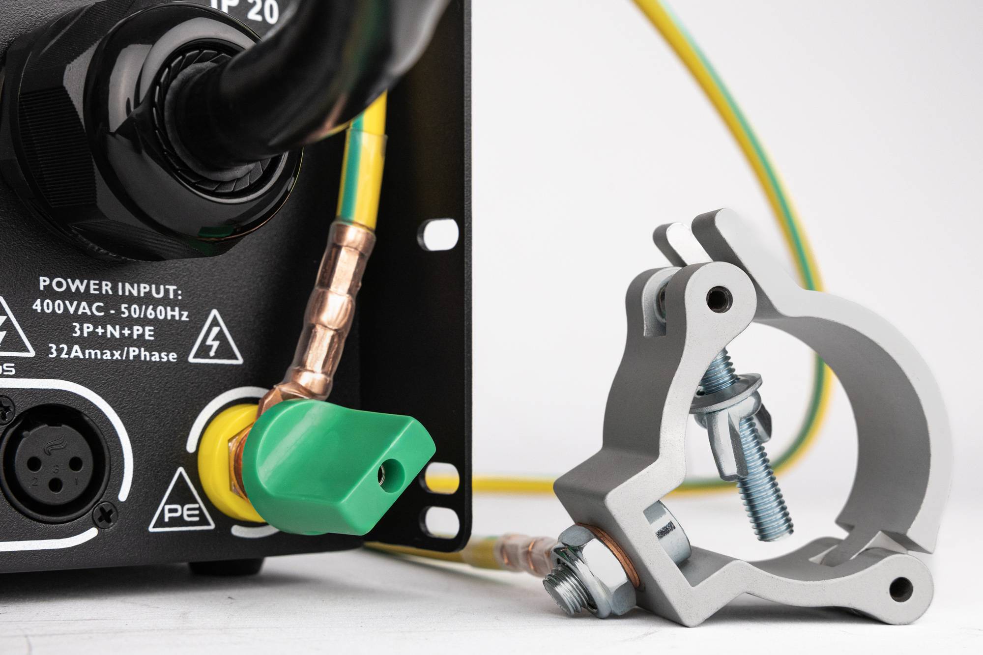 Das Bild zeigt eine elektrische Komponente mit einem schwarzen Kabel, einem grünen Schalter und gelben Leitungen. Rechts ist eine Klemme mit einer Schraube zu sehen.