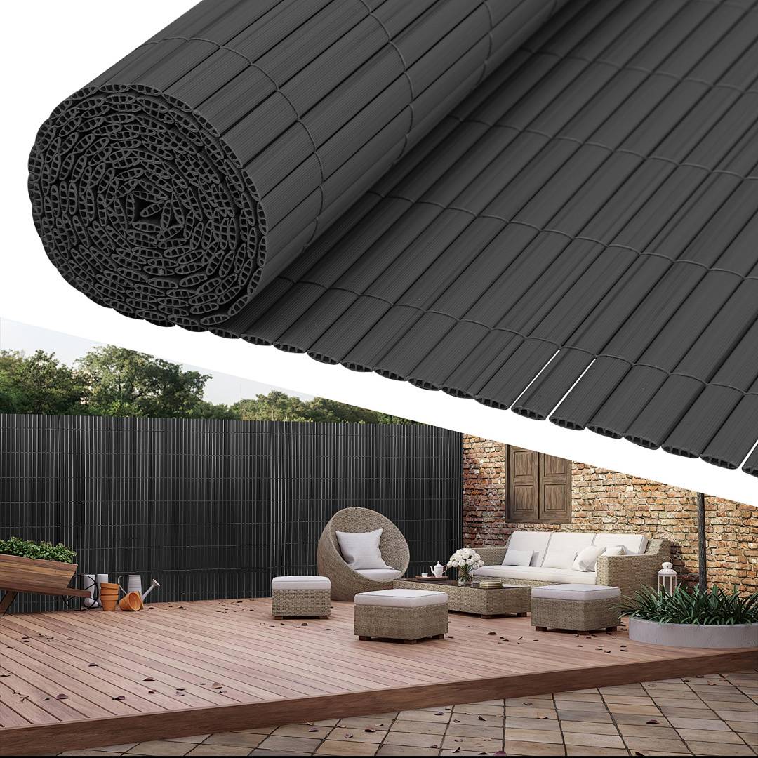 Outdoor-Terrasse mit moderner Möblierung, einem Holzdeck und Sichtschutzwänden aus gerolltem Bambus. Bäume und eine Ziegelwand befinden sich im Hintergrund.
