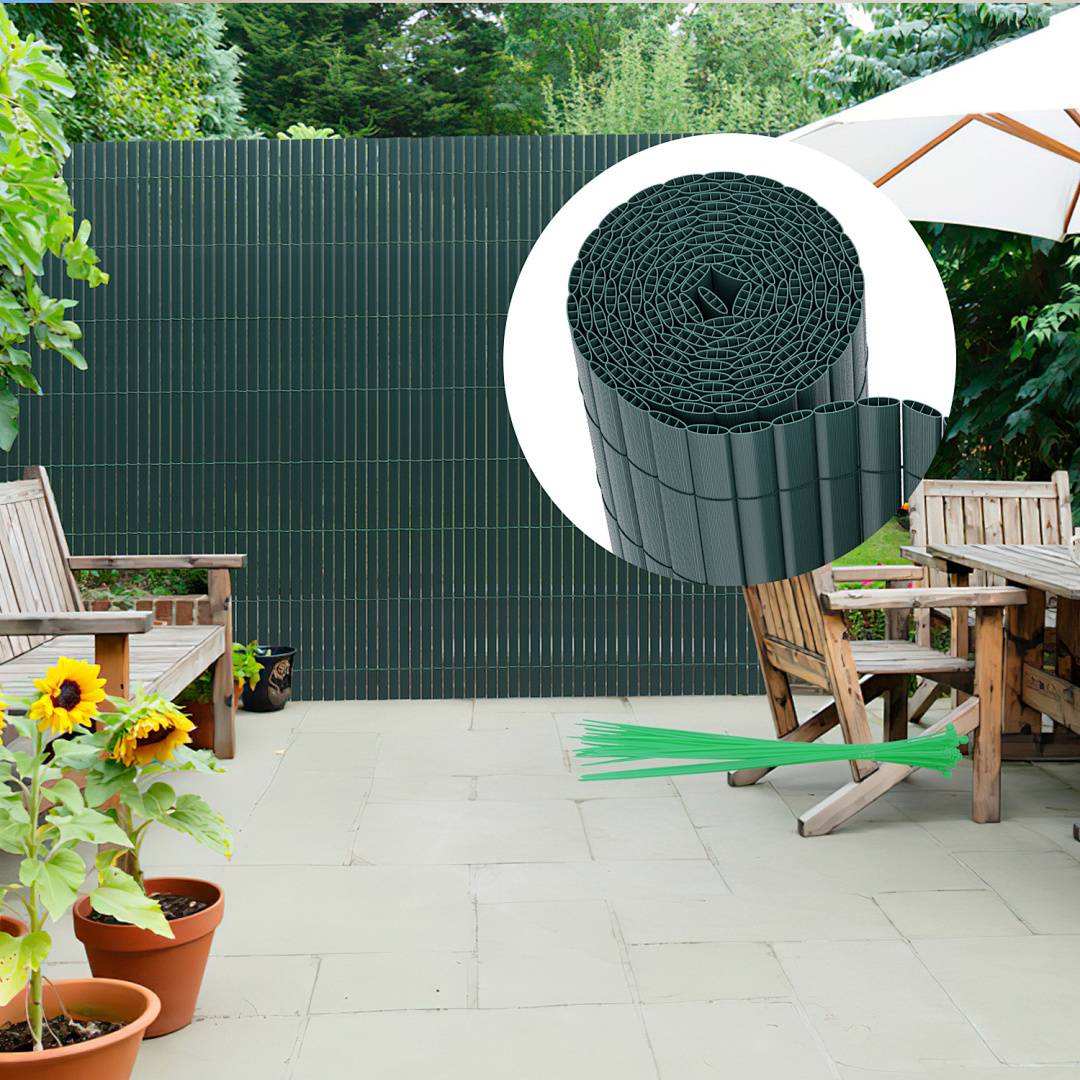 Outdoor-Terrasse mit Holztisch und Stühlen, Sonnenblumen in Töpfen und einem dunkelgrünen Sichtschutzzaun. Eingesetztes Bild zeigt eine Rolle des Zaunmaterials.