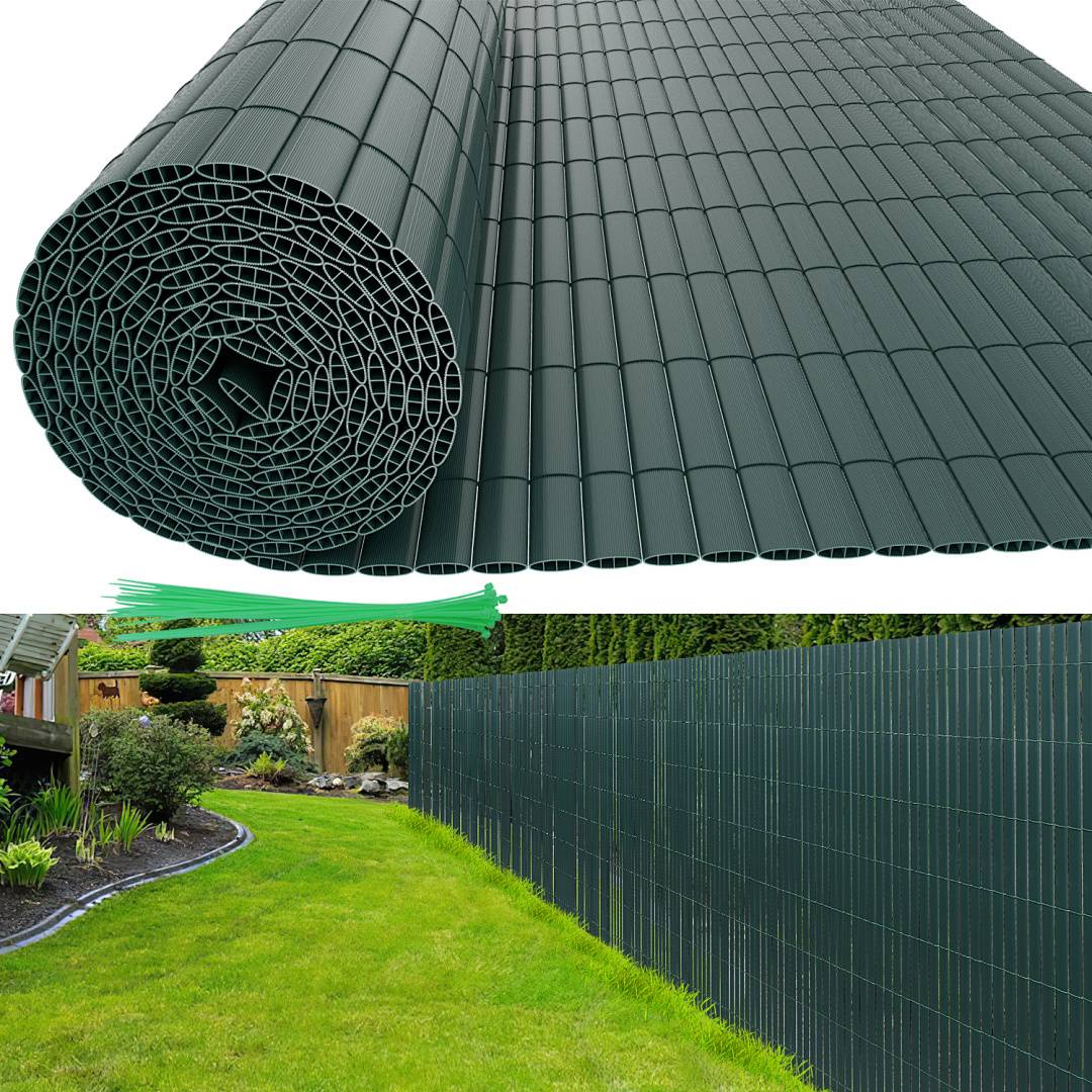 Ein Garten mit einem Holzzaun, der von einem dunkelgrünen, aufgerollten Sichtschutz verdeckt wird; üppiges Gras und Pflanzen sind im Hintergrund sichtbar.