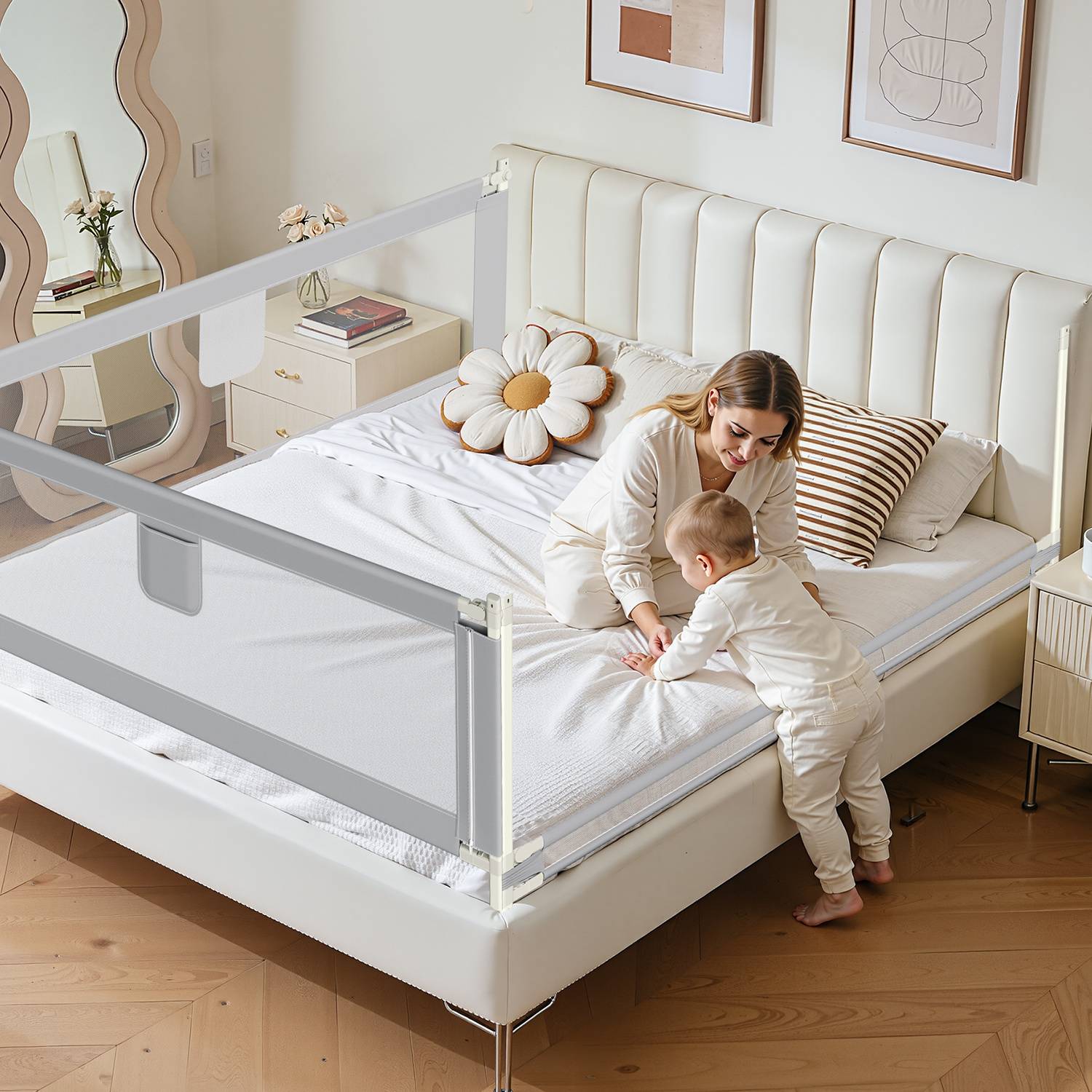 Ein Kleinkind und ein Erwachsener sitzen auf einem Bett mit weißen Leinenbezügen und Blumenkissen. Der Raum ist modern eingerichtet und verfügt über eine Sicherheitsschiene am Bett.