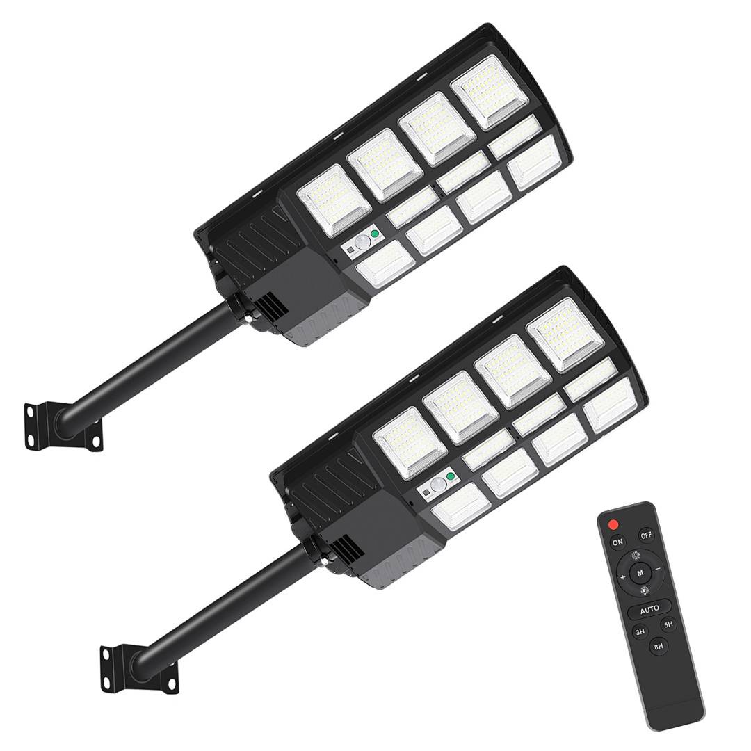 Zwei Outdoor-LED-Solarleuchten mit Halterarmen und einer Fernbedienung, ausgestattet mit mehreren rechteckigen Lichtpaneelen, die vor einem weißen Hintergrund präsentiert werden.