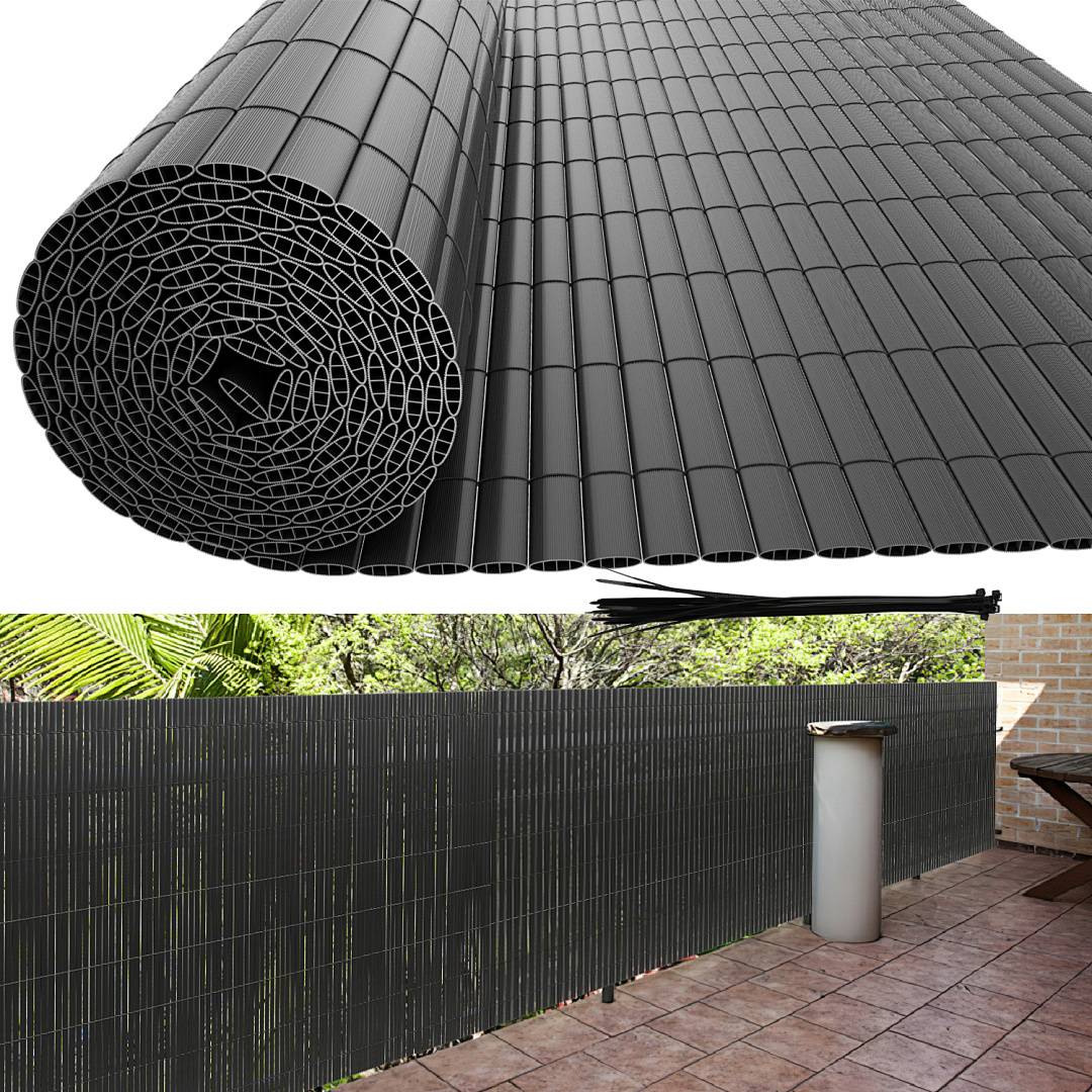 Eine aufgerollte schwarze Außen-Sichtschutzrolle, teilweise ausgerollt, mit Blick auf ihre Installation auf einer Terrasse, die Schatten und Privatsphäre bietet.
