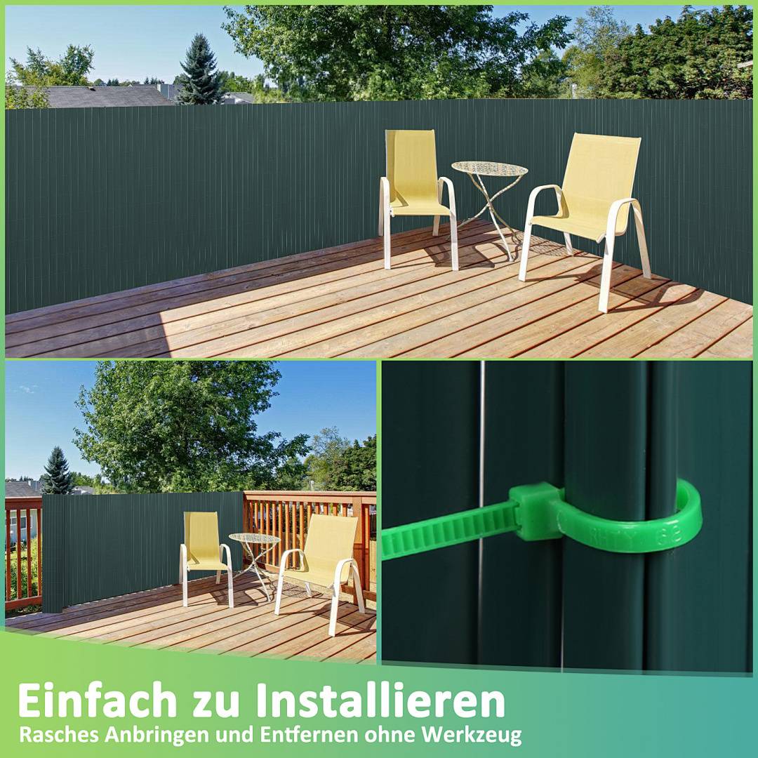 Zwei gelbe Stühle und ein Tisch auf einer Holzterrasse mit einem grünen Sichtschutzzaun, umgeben von Bäumen. Deutscher Text lautet: 'Einfach zu installieren: Rasches Anbringen und Entfernen ohne Werkzeug.