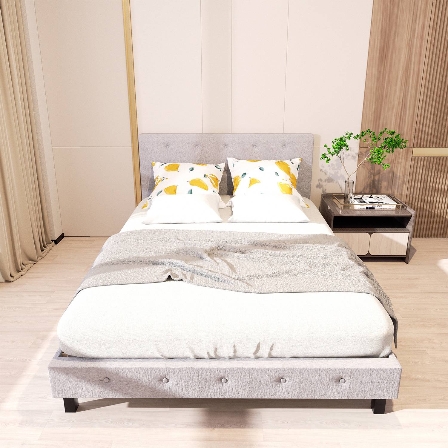 Ein modernes Schlafzimmer zeigt ein sorgfältig gemachtes Bett mit einem grauen gepolsterten Kopfteil, weißer Bettwäsche und Zierkissen mit Zitronenmuster, neben einem Nachttisch.