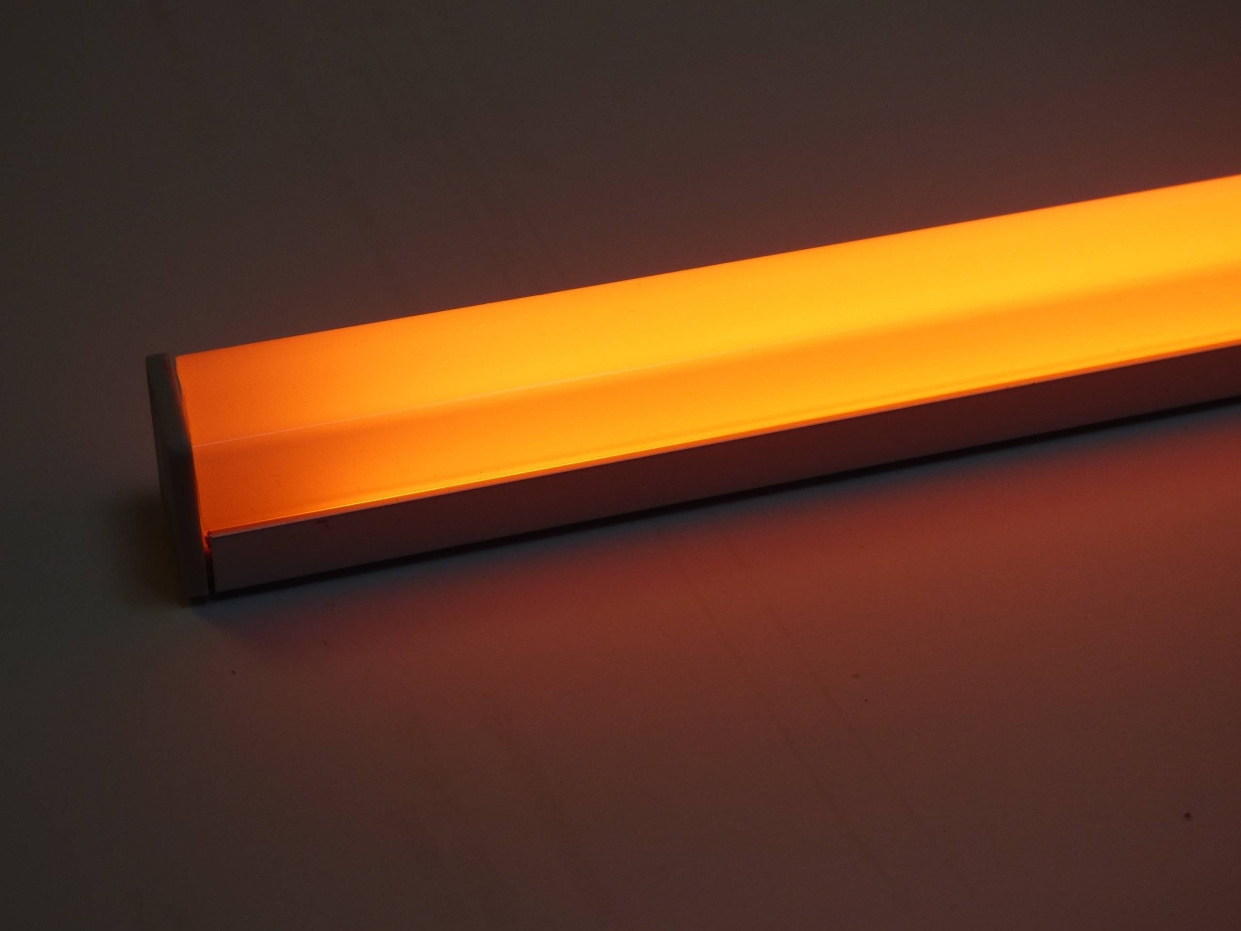 Eine leuchtend orange LED-Lichtleiste vor einem dunklen Hintergrund, die ihre Beleuchtung und ihr schlankes Design zeigt.