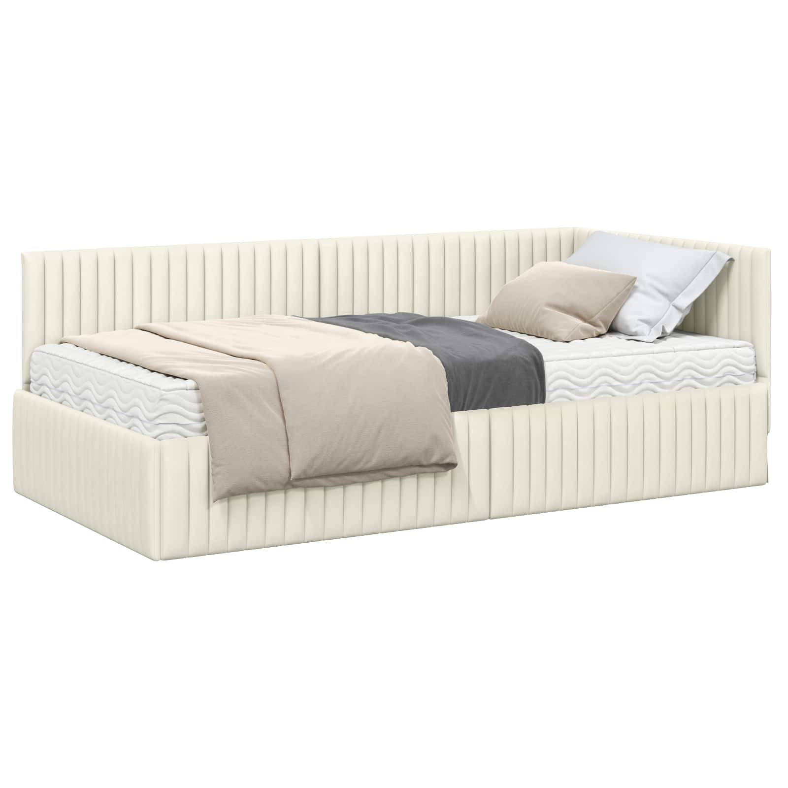 Ein cremefarbenes Tagesbett mit minimalistischem Design, ausgestattet mit einer grauen und beigen geschichteten Bettwäsche und zwei Kissen, in einer Ecke platziert.