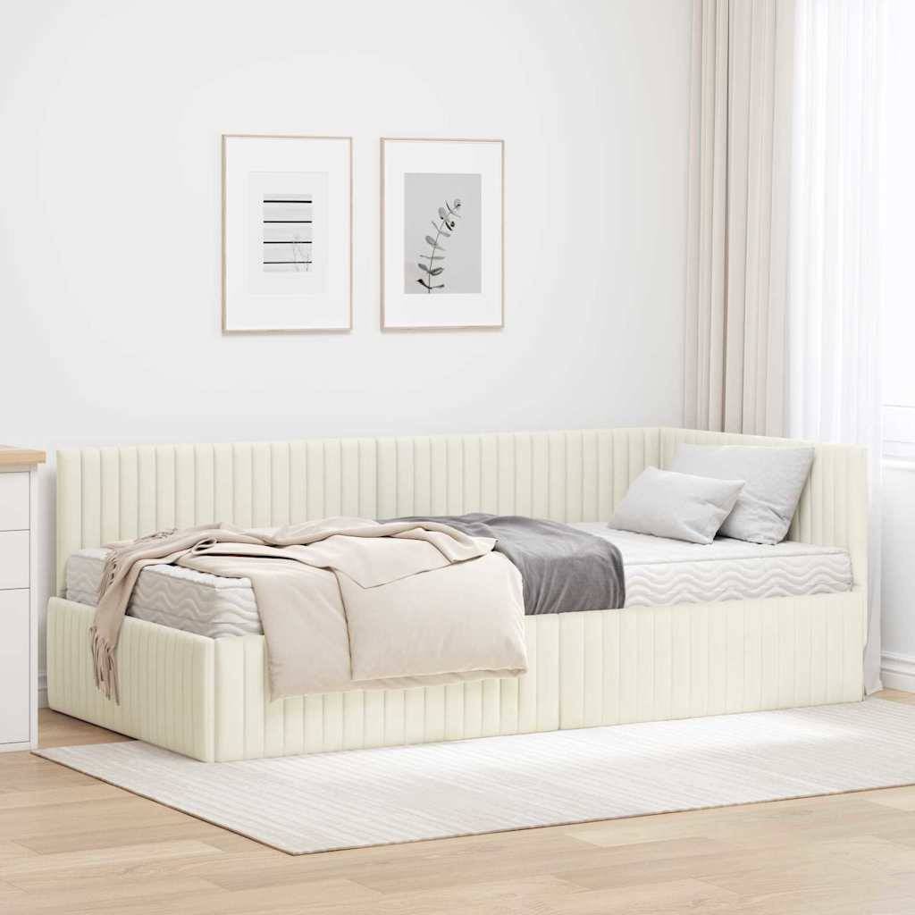 Ein modernes beiges Tagesbett mit gestreifter Polsterung steht in einem hellen Raum. Es ist mit neutralen Decken und Kissen unter zwei gerahmten Wanddrucken gestylt.