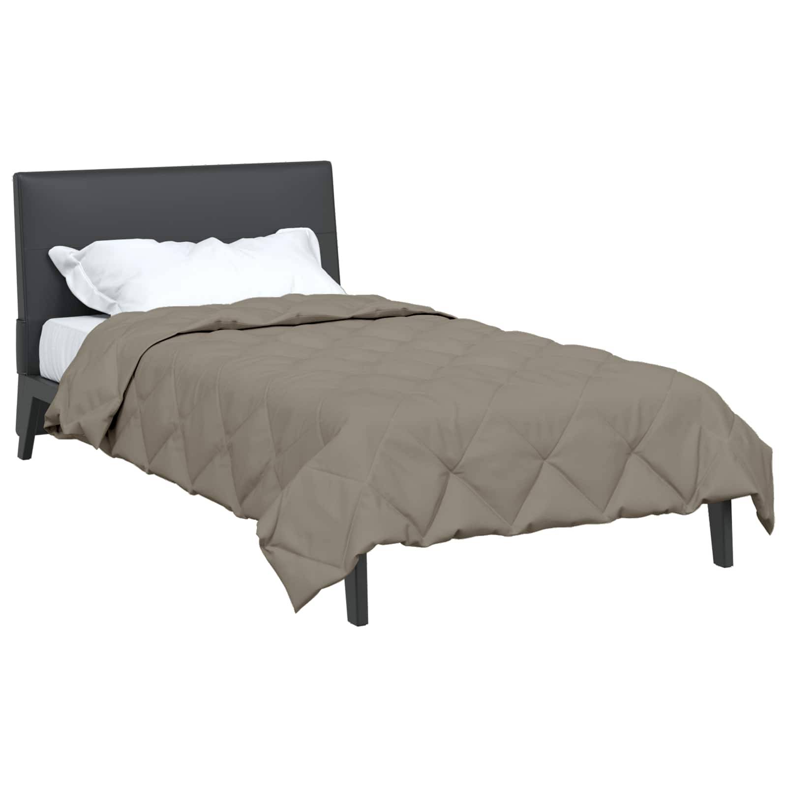 Ein einfaches Bett mit dunklem Kopfteil, weißen Kissen und einer beigen gesteppten Decke. Das Bett ist gemacht und wirkt einsatzbereit.