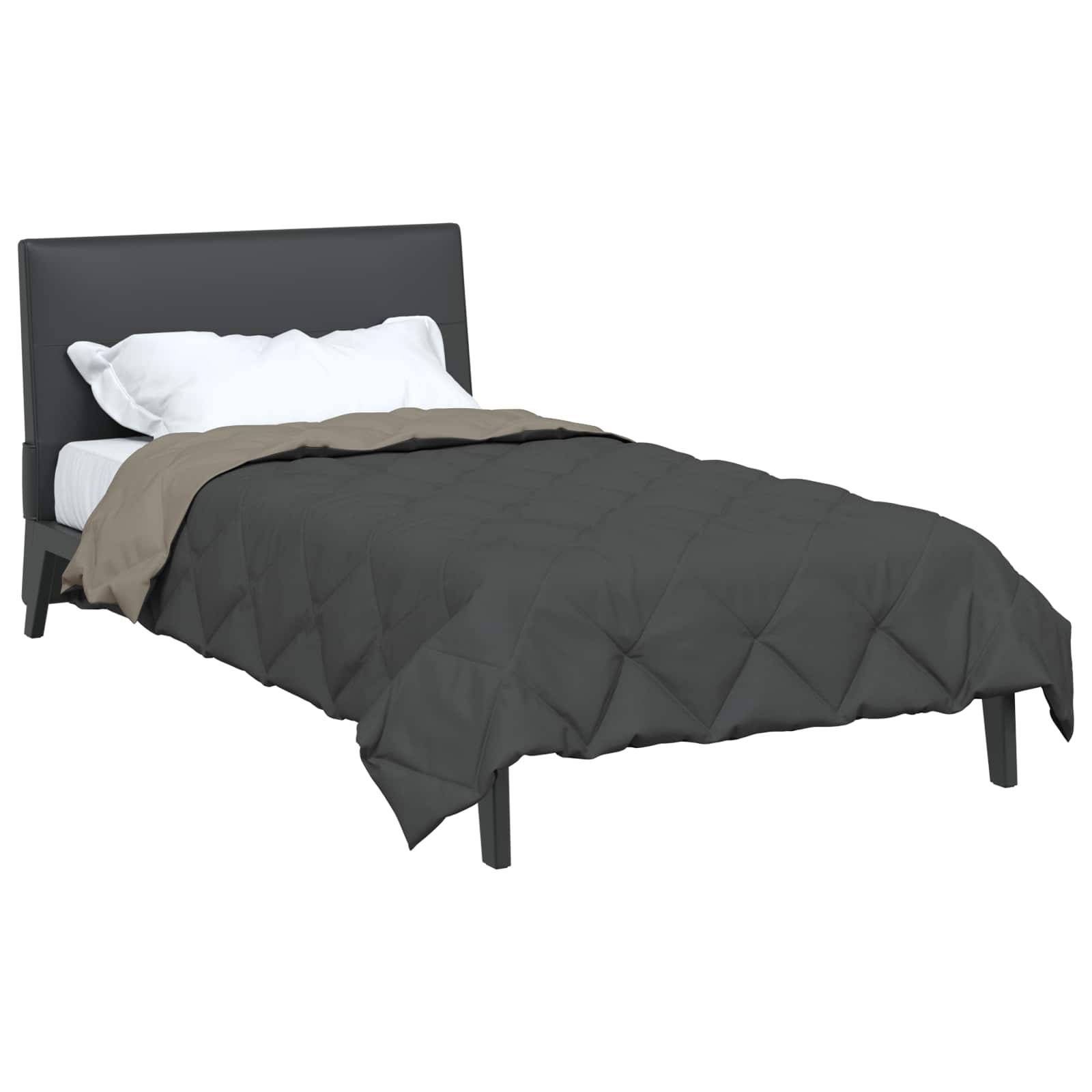 Ein ordentlich gemachtes Bett mit einer dunkelgrauen Bettdecke, einer beigen Decke und weißen Kissen an einem schwarzen Kopfteil.