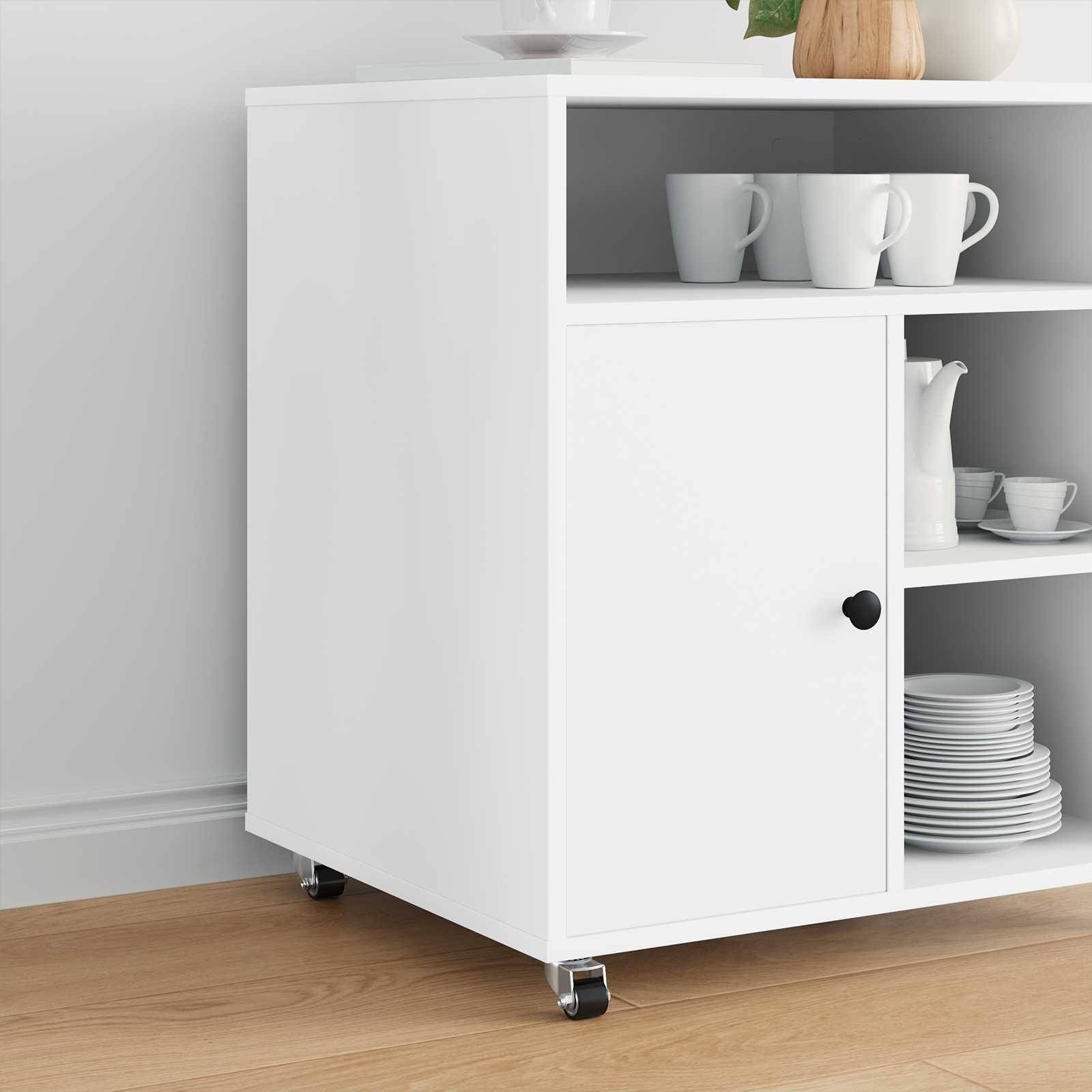Ein weißer Küchenschrank auf Rollen mit Tassen, Tellern und einer Kanne, die auf verschiedenen Regalen platziert sind, steht vor einer hellen Wand auf Holzboden.