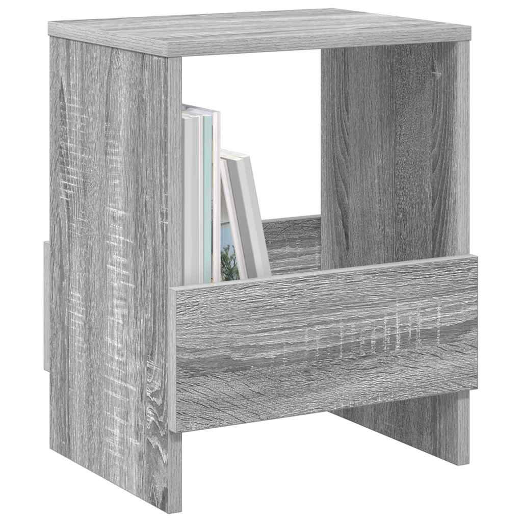 Ein grauer Holznachttisch mit einer Schublade und einem offenen Regal, das teilweise mit zwei Büchern bestückt ist.