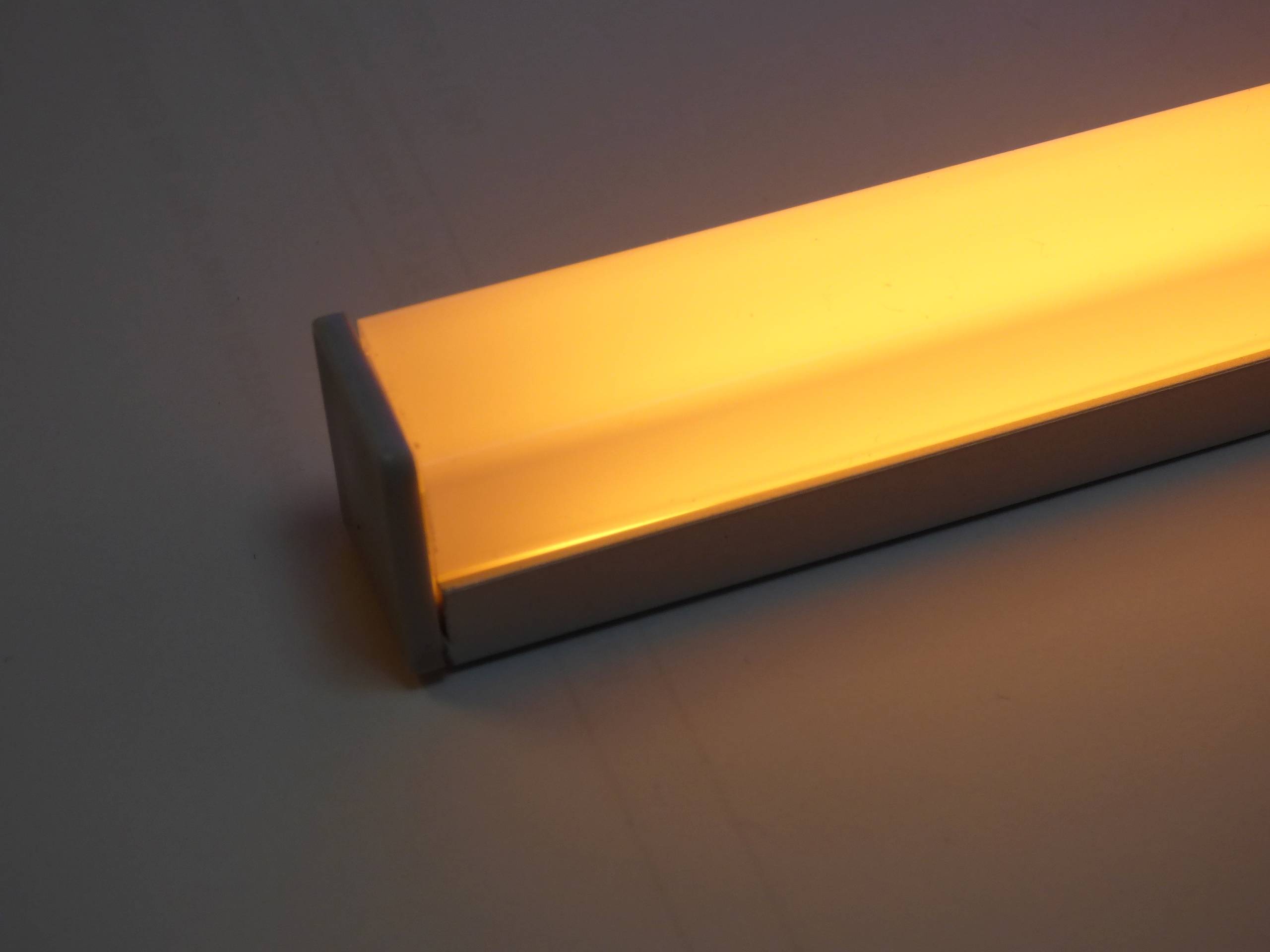 Eine rechteckige LED-Leuchte mit warmem Bernsteinglanz, die in einem Metallrahmen montiert ist und sich für ambientes Innenraumlicht eignet.