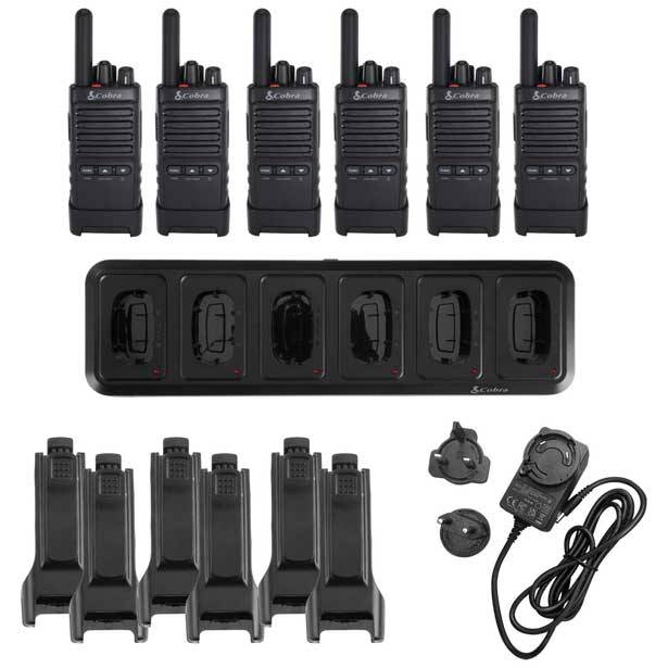 Acht schwarze Handfunkgeräte mit passenden Ladegeräten und Zubehör, einschließlich Headsets und einer Ladestation für mehrere Geräte, ordentlich arrangiert.