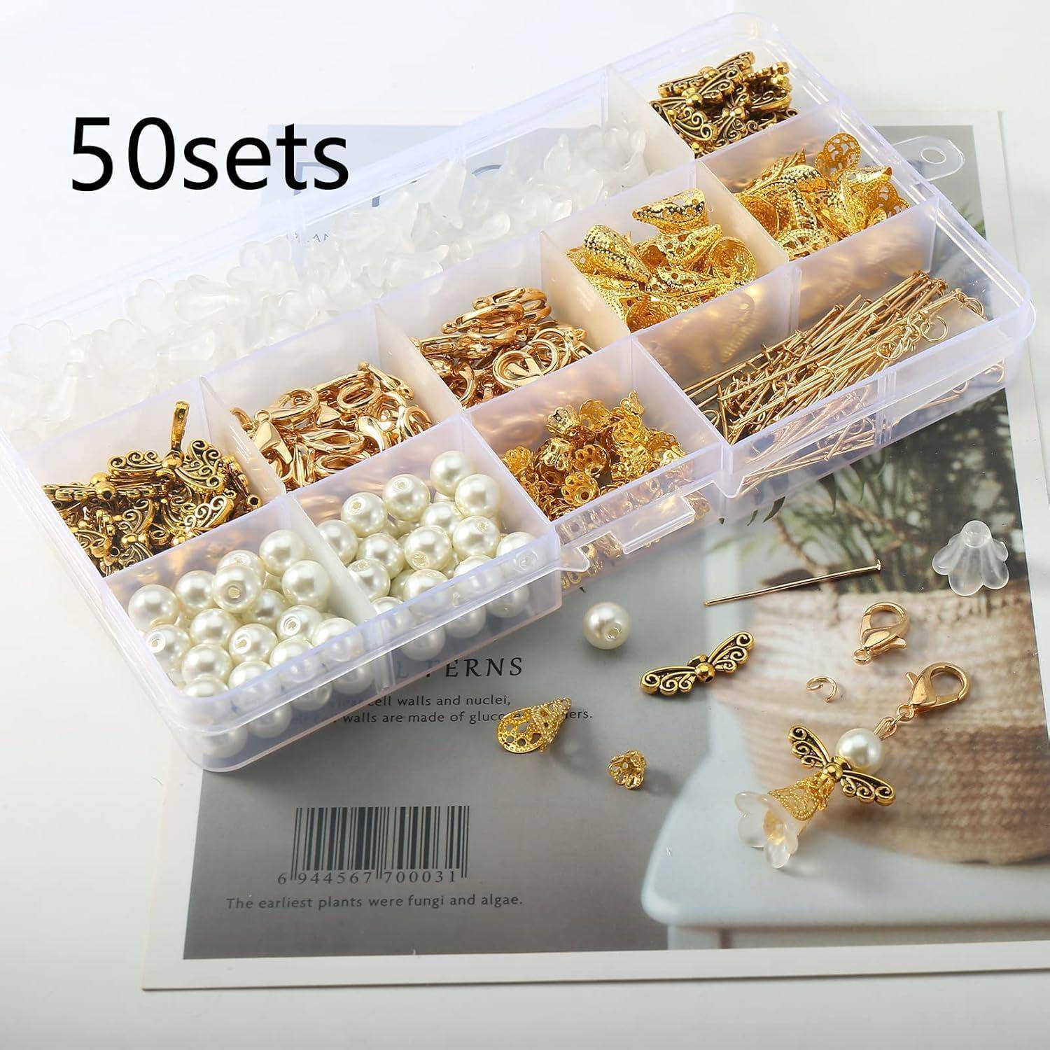 Eine durchsichtige Box mit 50 Sets goldener Schmuckbefestigungen, einschließlich Pins, Anhänger und weißer Perlen, ausgelegt auf einem Faltblatt.