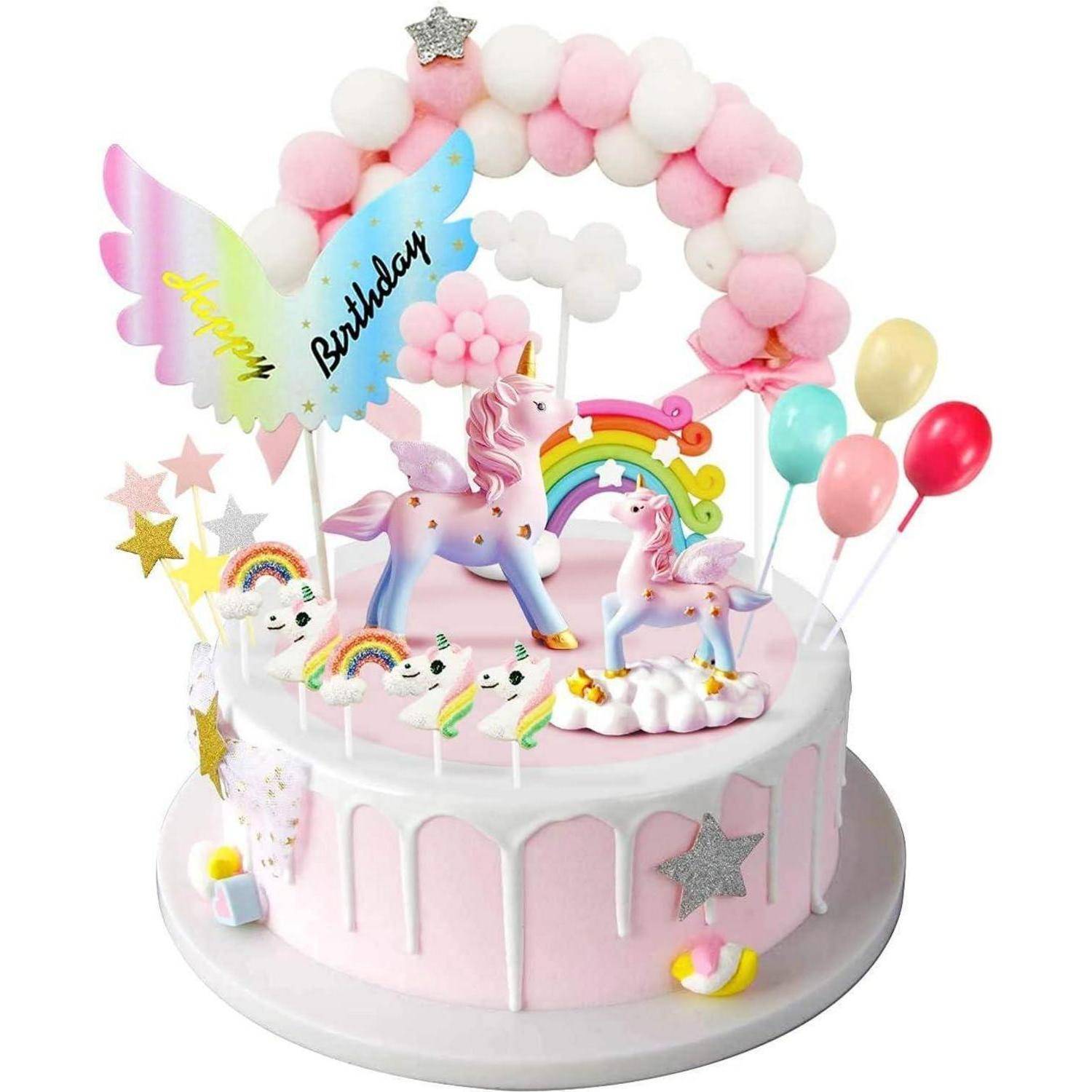 Eine farbenprächtige Geburtstagstorte mit Einhornfiguren, Regenbögen und Luftballons. Der Tortendekoration ist mit 