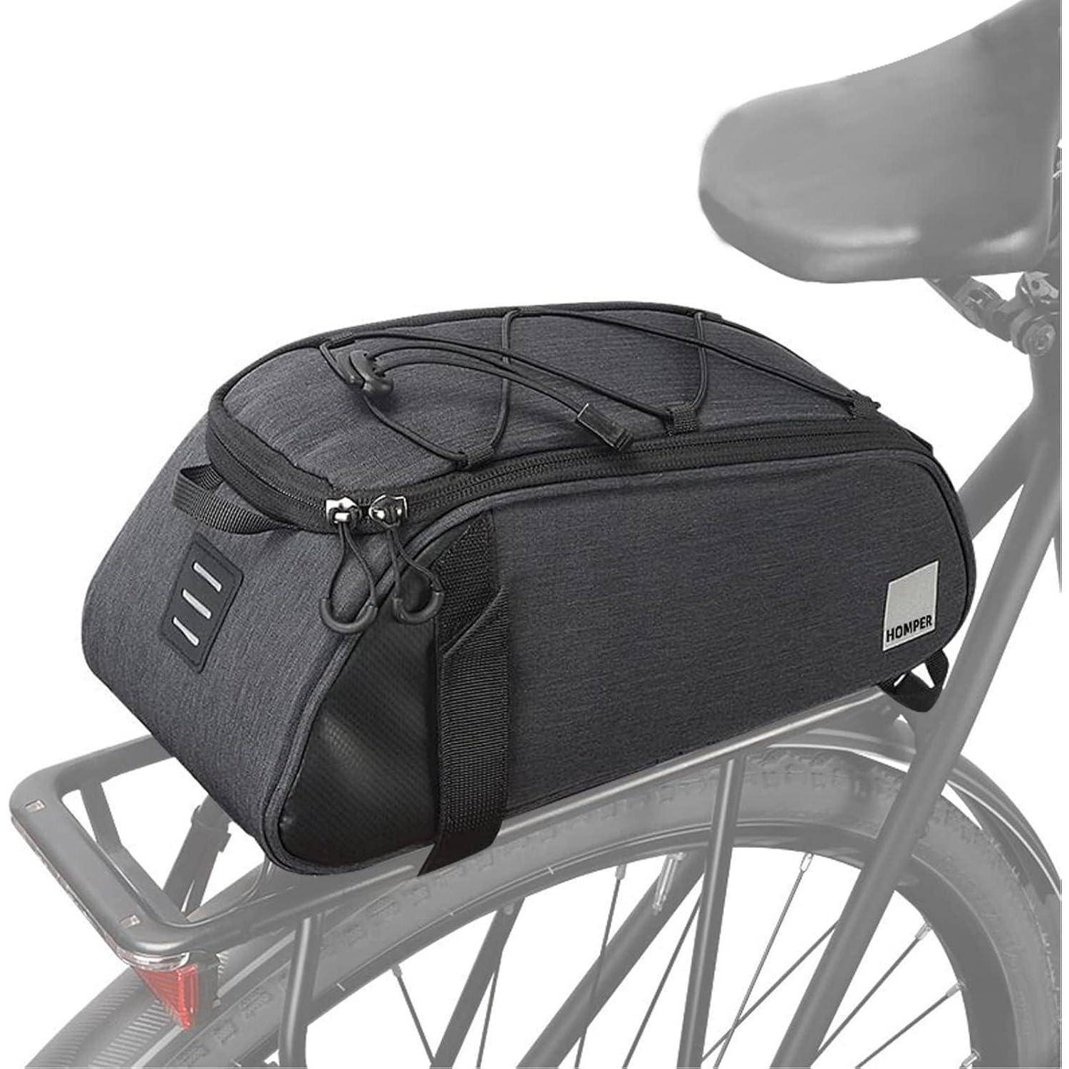 Eine schwarze Fahrradtasche ist sicher am Gepäckträger eines Fahrrads befestigt und zeigt ihr kompaktes Design sowie elastische Kordeln oben für zusätzlichen Stauraum.