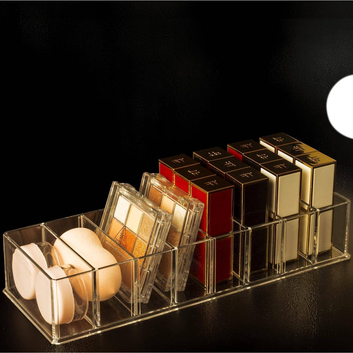 Ein transparenter Acryl-Organizer, der runde Pudercompacts, vier Lidschatten-Paletten und mehrere quadratische Make-up-Etuis in einer ordentlichen Anordnung enthält.