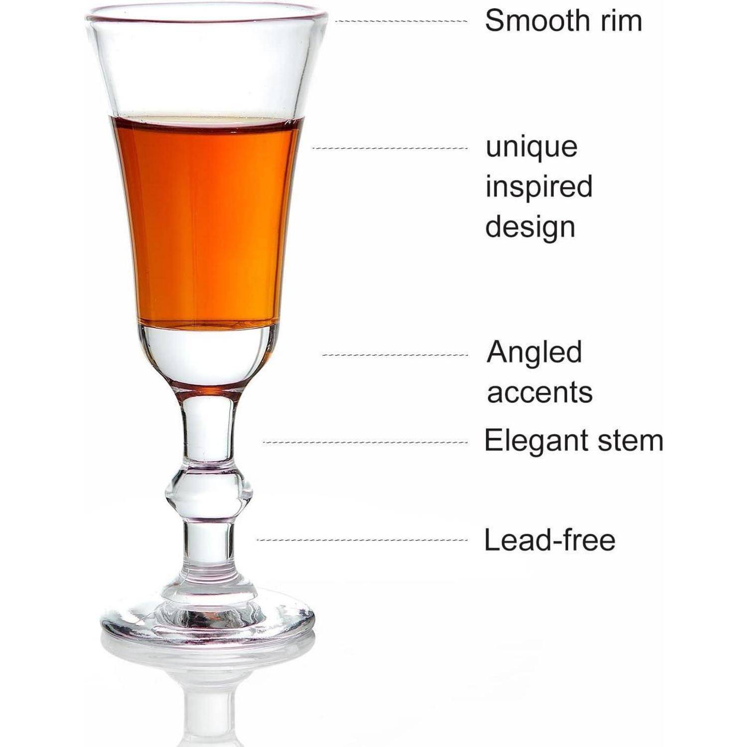 Ein Glas mit orangefarbener Flüssigkeit verfügt über einen glatten Rand, ein einzigartiges Design, schräge Akzente an seinem eleganten Stiel und ist mit der Aufschrift „Bleifrei