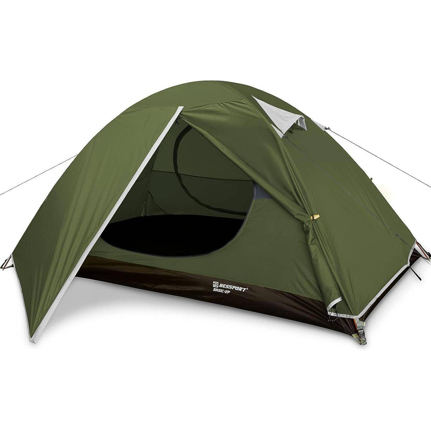 Ein grünes Campingzelt ist aufgestellt, wobei der Eingang geöffnet ist und das Innere sichtbar macht. Das Zelt hat eine Kuppelform und ist im Freien aufgebaut.