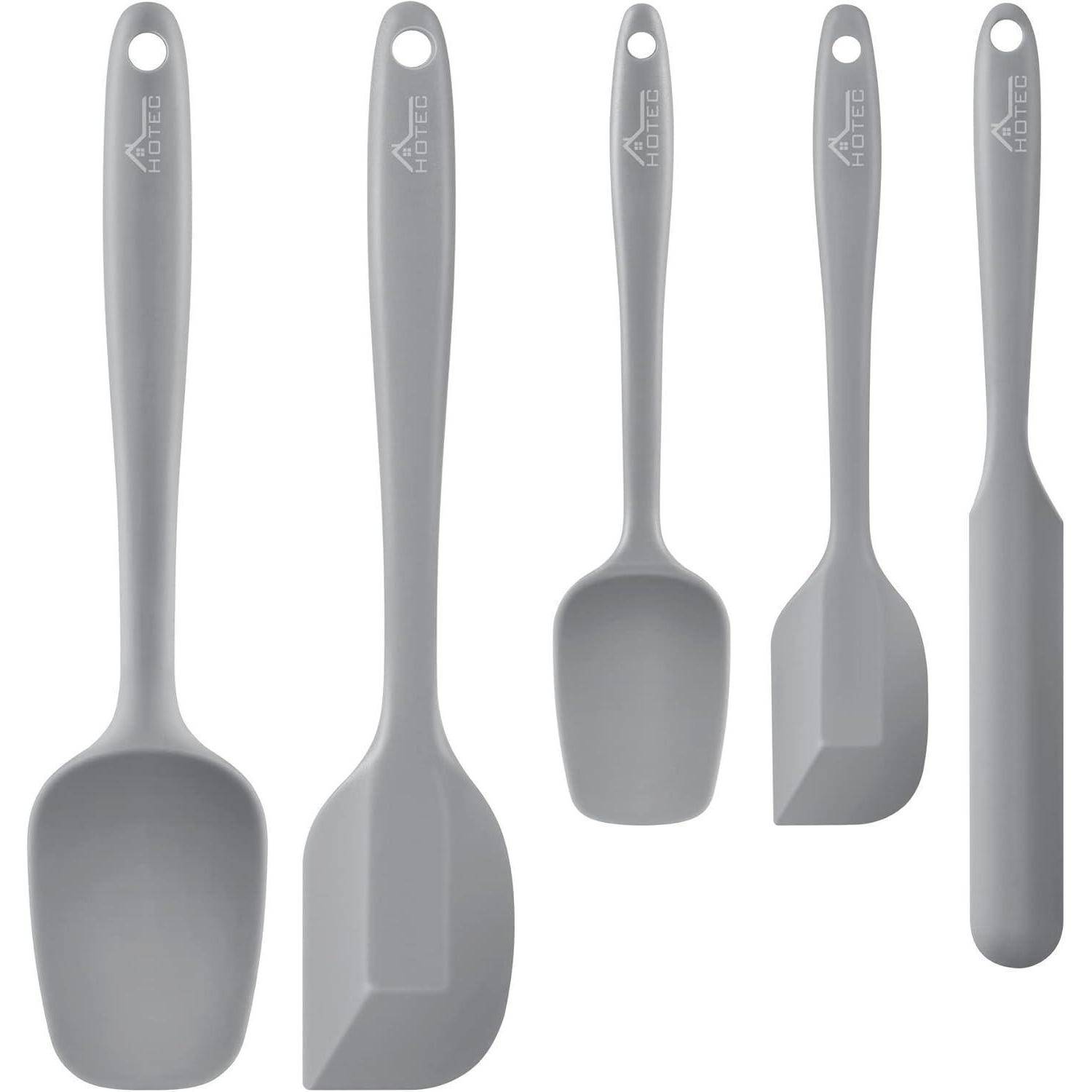 Ein Set aus fünf grauen Silikonspatel in unterschiedlichen Größen, die zum Kochen und Backen verwendet werden. Jeder Spatel verfügt über ein nahtloses Design und einen mit einer Marke versehenen Griff.