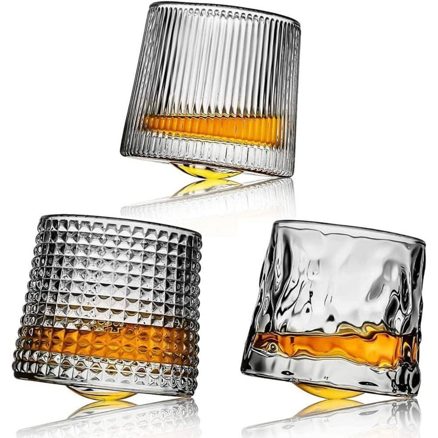 Drei einzigartige Whiskeygläser, jedes mit unterschiedlichen Texturen, sind mit bernsteinfarbener Flüssigkeit gefüllt. Sie erscheinen geneigt und zeigen so ihr Design.