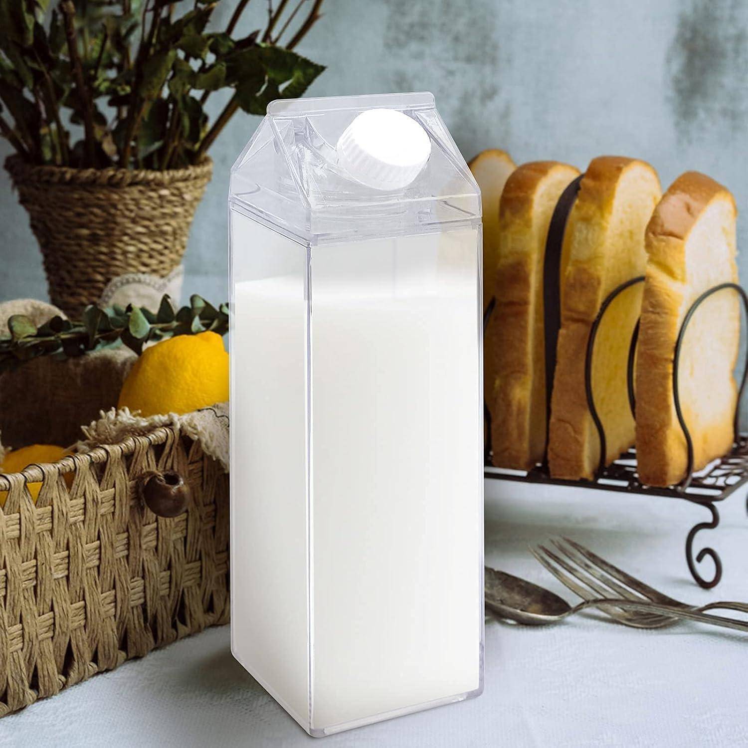 Eine transparente rechteckige Milchpackung auf einem Tisch mit geschnittenem Brot und einem Korb mit Zitronen im Hintergrund.