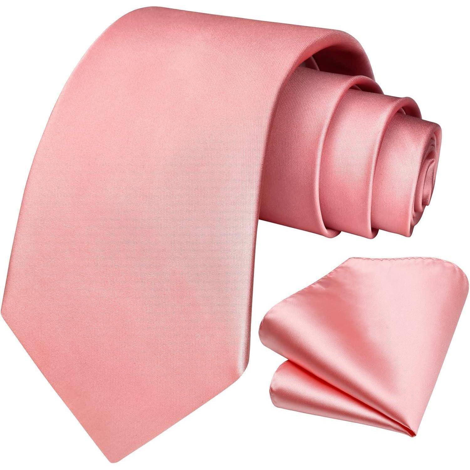 Eine aufgerollte rosa Seidenkrawatte mit einem passenden, gefalteten Einstecktuch daneben.