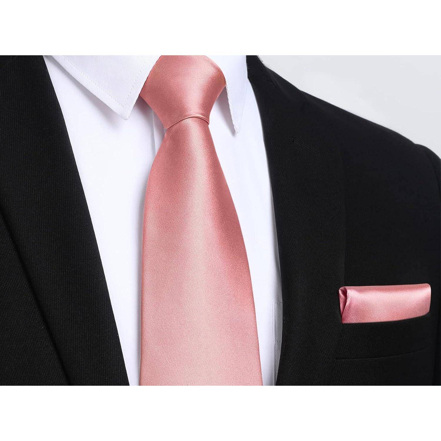 Eine Person trägt einen schwarzen Anzug mit einem weißen Hemd. Die Krawatte und das Einstecktuch sind beide rosa, was einen formellen und stilvollen Look ergibt.