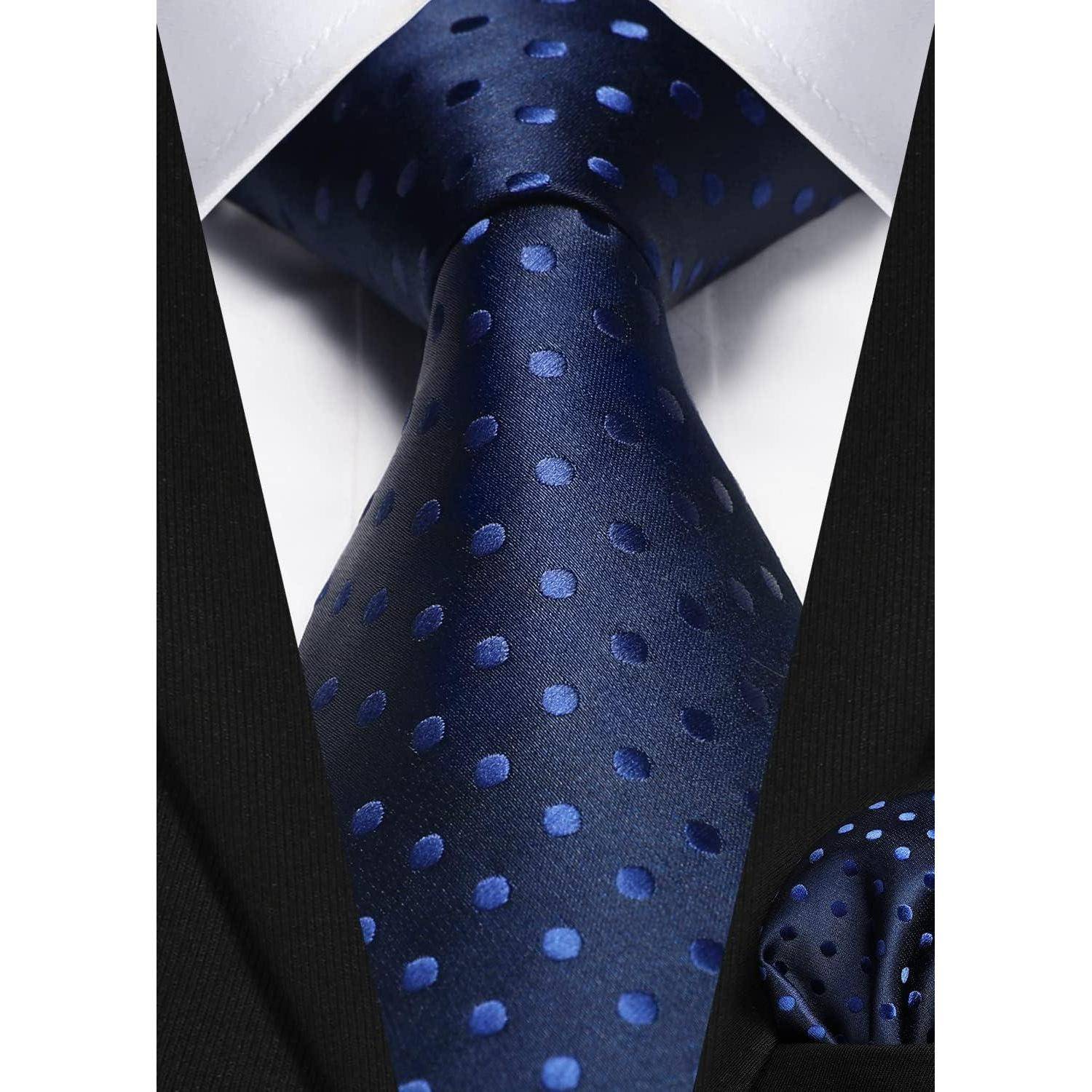 Eine Nahaufnahme eines schwarzen Anzugs mit einer blauen Polka-Dot-Krawatte und passendem Einstecktuch, die Details der formellen Kleidung hervorhebt.