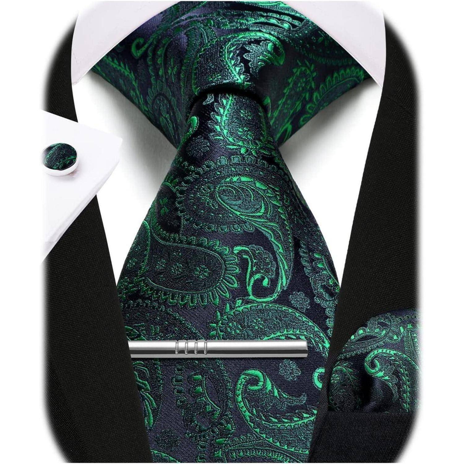Eine schwarze und grüne Paisley-Krawatte und ein gefaltetes Einstecktuch, kombiniert mit einer schwarzen Anzugsjacke und einem weißen Hemd, wodurch ein formeller Look entsteht.