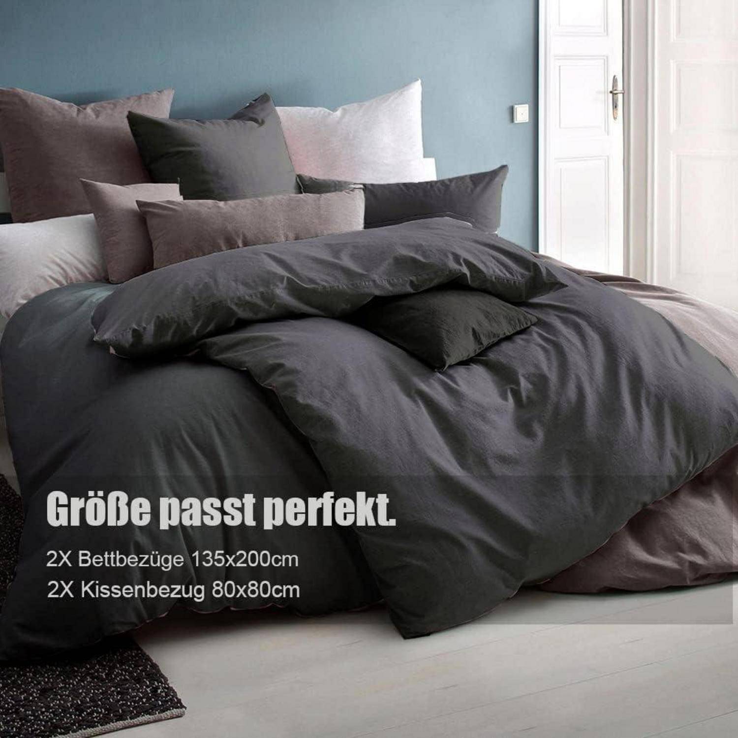 Ein ordentlich angeordneter Satz dunkelgrauer Bettwäsche und Kissenbezüge auf einem Bett, mit Texteinblendung in Deutsch, die Größen für Bettdeckenbezüge und Kissenbezüge angibt.