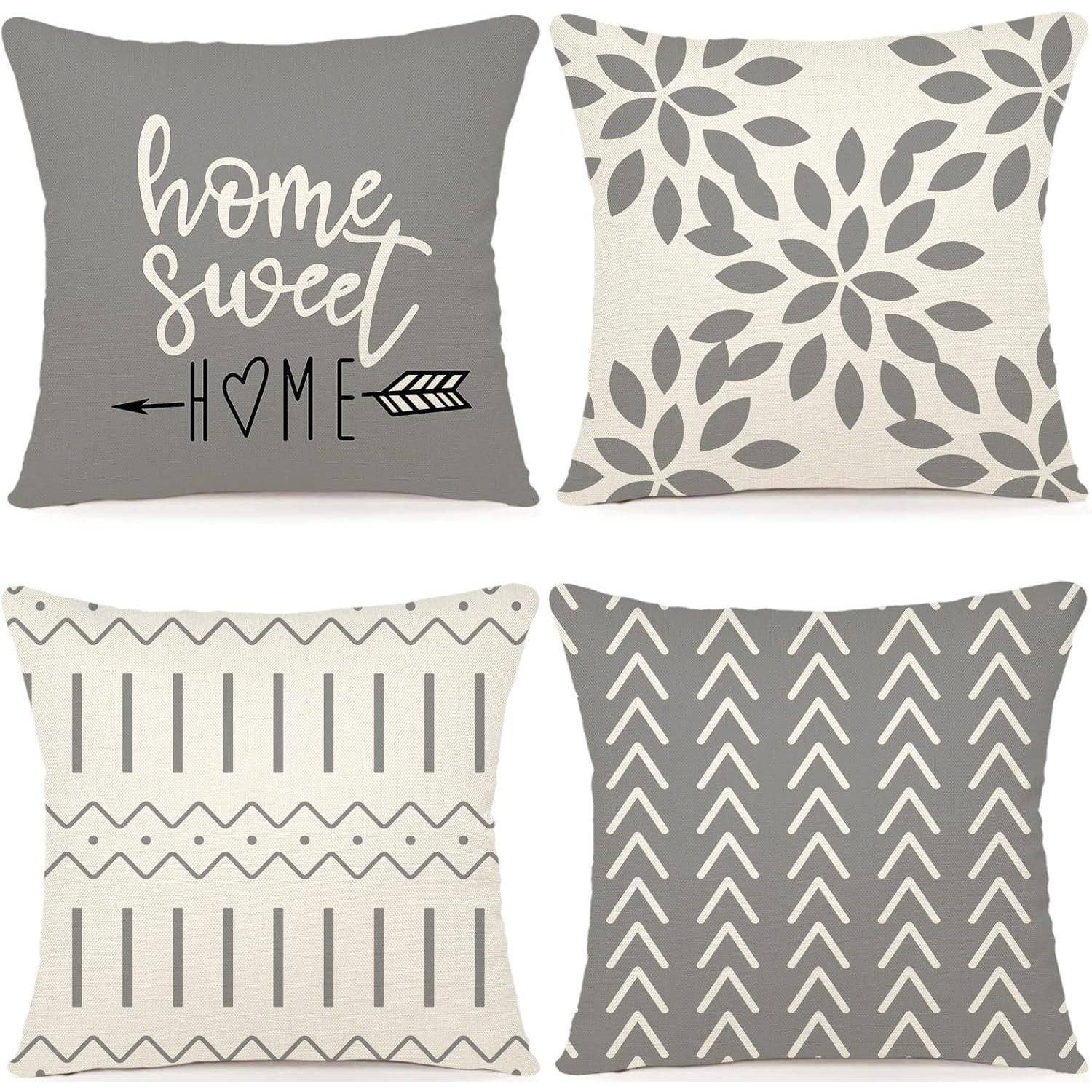 Vier dekorative Kissen mit Mustern. Oben links: 'Home sweet home' Text mit Pfeil. Oben rechts: Blattdesign. Unten links: vertikale Streifen. Unten rechts: Zickzackmuster.