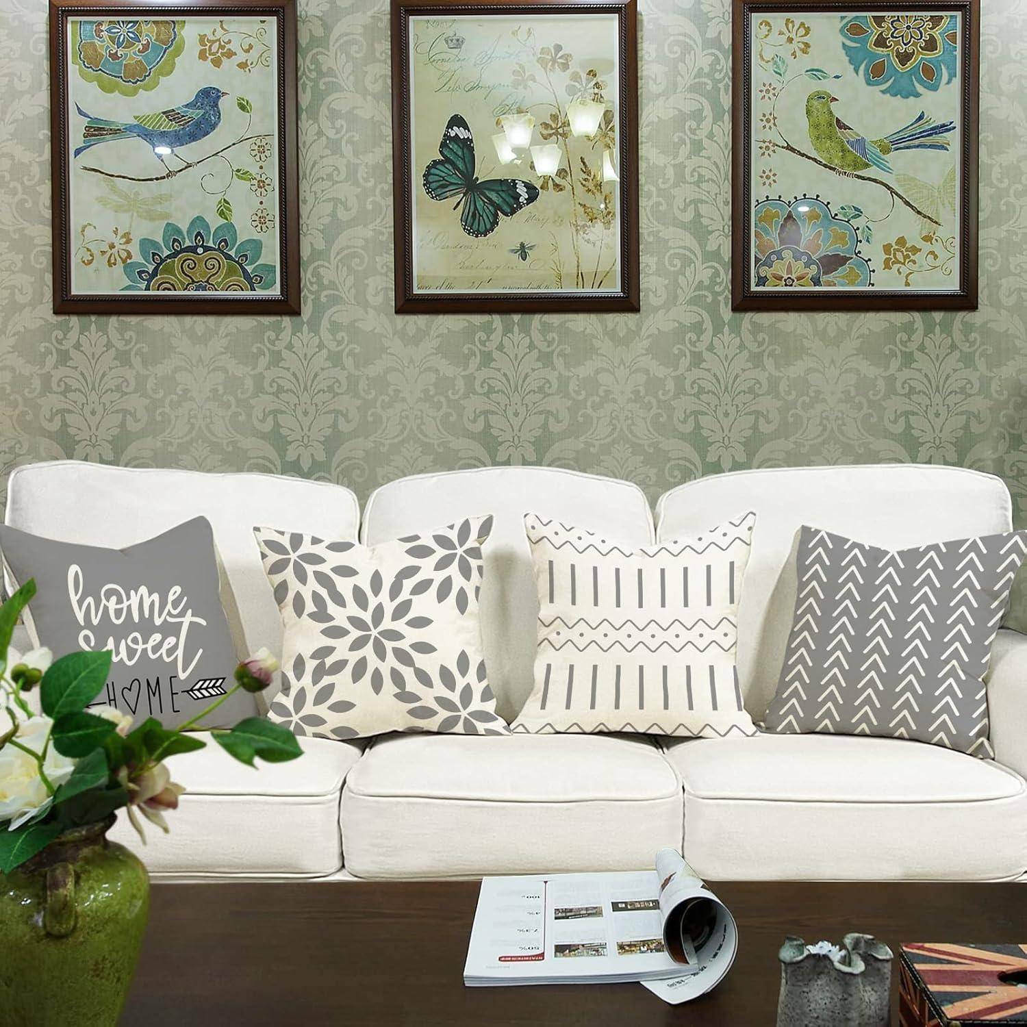 Ein Wohnzimmer mit einem weißen Sofa, gemusterten Kissen und gerahmter Schmetterlingskunst an der Wand, die eine gemütliche und dekorative Atmosphäre schaffen.