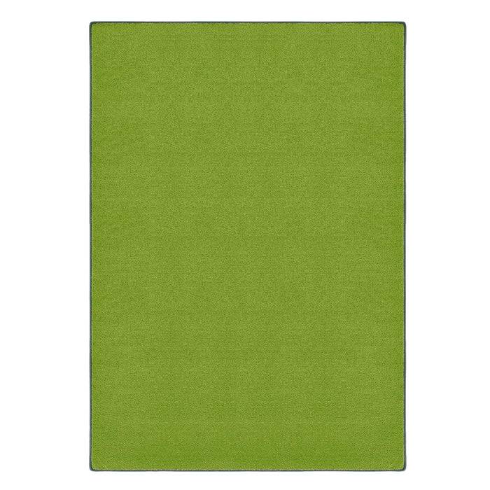 Ein lebhaft grüner rechteckiger Teppich mit einem dünnen dunklen Rand, der flach auf einer Oberfläche ausgebreitet ist.
