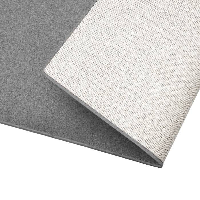 Ein Nahaufnahme-Bild eines texturierten, gefalteten Textils. Die Oberseite ist hellgrau mit einem feinen Gittermuster, während die Unterseite einfarbig dunkelgrau ist.