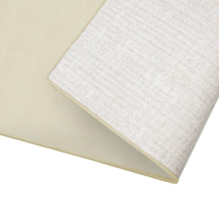 Ein gefaltetes hellbeiges Stoffstück mit einem weißen Gittermuster präsentiert Textur und Designdetails.