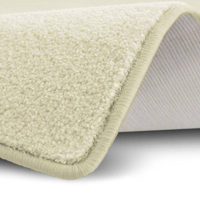 Eine Nahaufnahme einer Ecke eines hellbeigen, plüschigen Teppichs, die dessen Textur und Dicke auf weißem Hintergrund zeigt und Weichheit suggeriert.