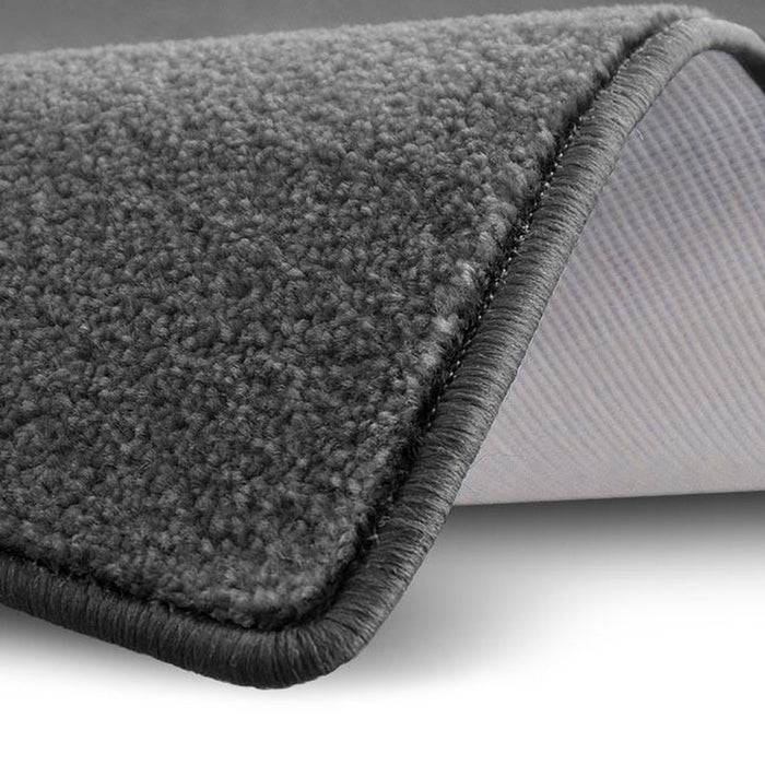 Nahaufnahme einer grauen Fleecestoff-Kante, die ihre weiche Textur und den gestickten Rand vor einem schlichten weißen Hintergrund zeigt.