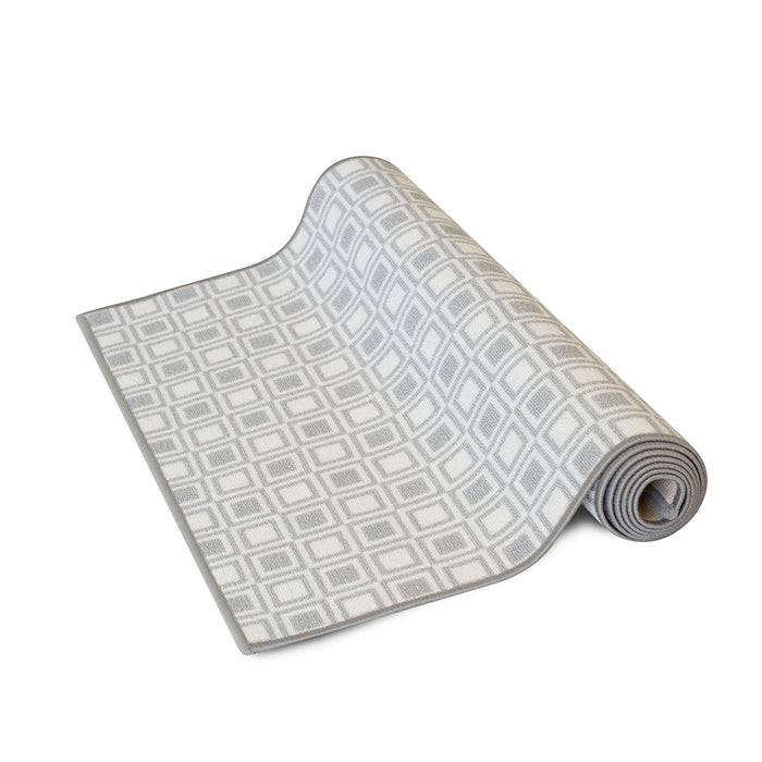 Eine hellgraue und weiße aufgerollte Yogamatte mit einem geometrischen Rautenmuster, die ihre strukturierte Oberfläche hervorhebt.