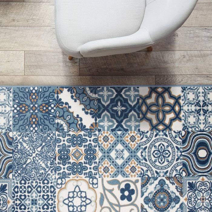 Ein weißer Stuhl auf einem Holzboden neben einem blauen und weißen gemusterten Teppich mit kunstvollen Ornamenten.