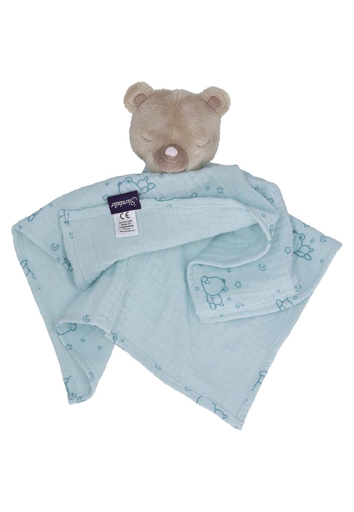 Ein Plüsch-Teddybärkopf, der an einer hellblauen Babydecke mit kleinen Teddybären-Motiven befestigt ist, die für das Wohlbefinden und die Sicherheit des Babys konzipiert wurde.