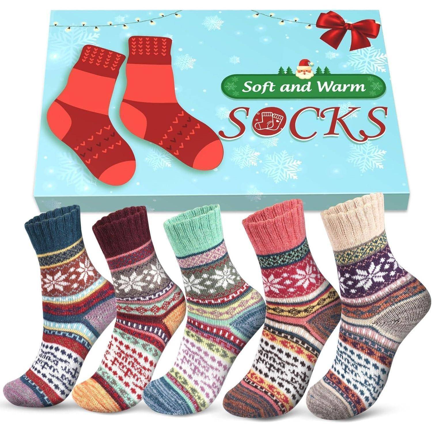 Fünf Paare bunter gemusterter Socken, die unterhalb einer festlichen Geschenkbox mit der Aufschrift 