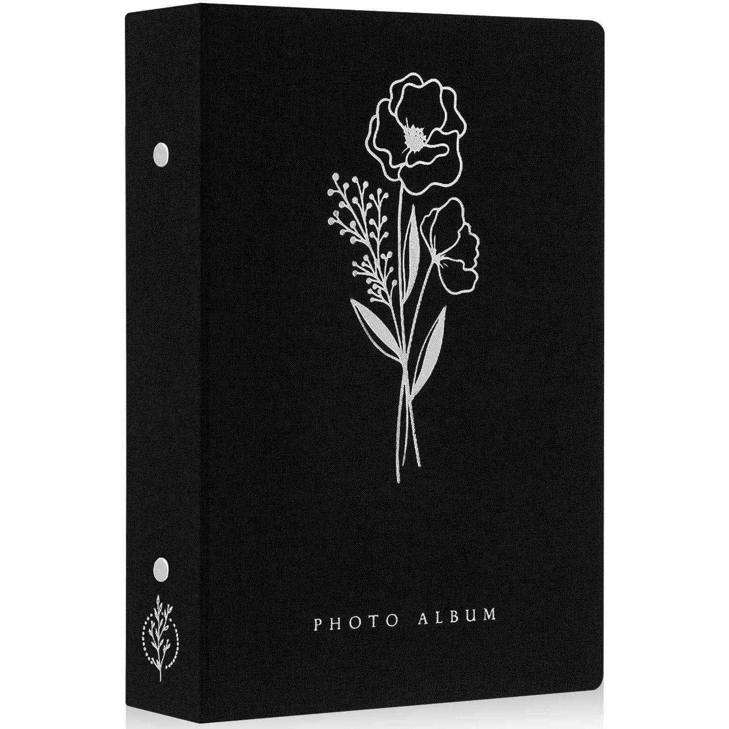 Ein schwarzes Fotoalbum mit einer weißen Blumenillustration und dem Text 