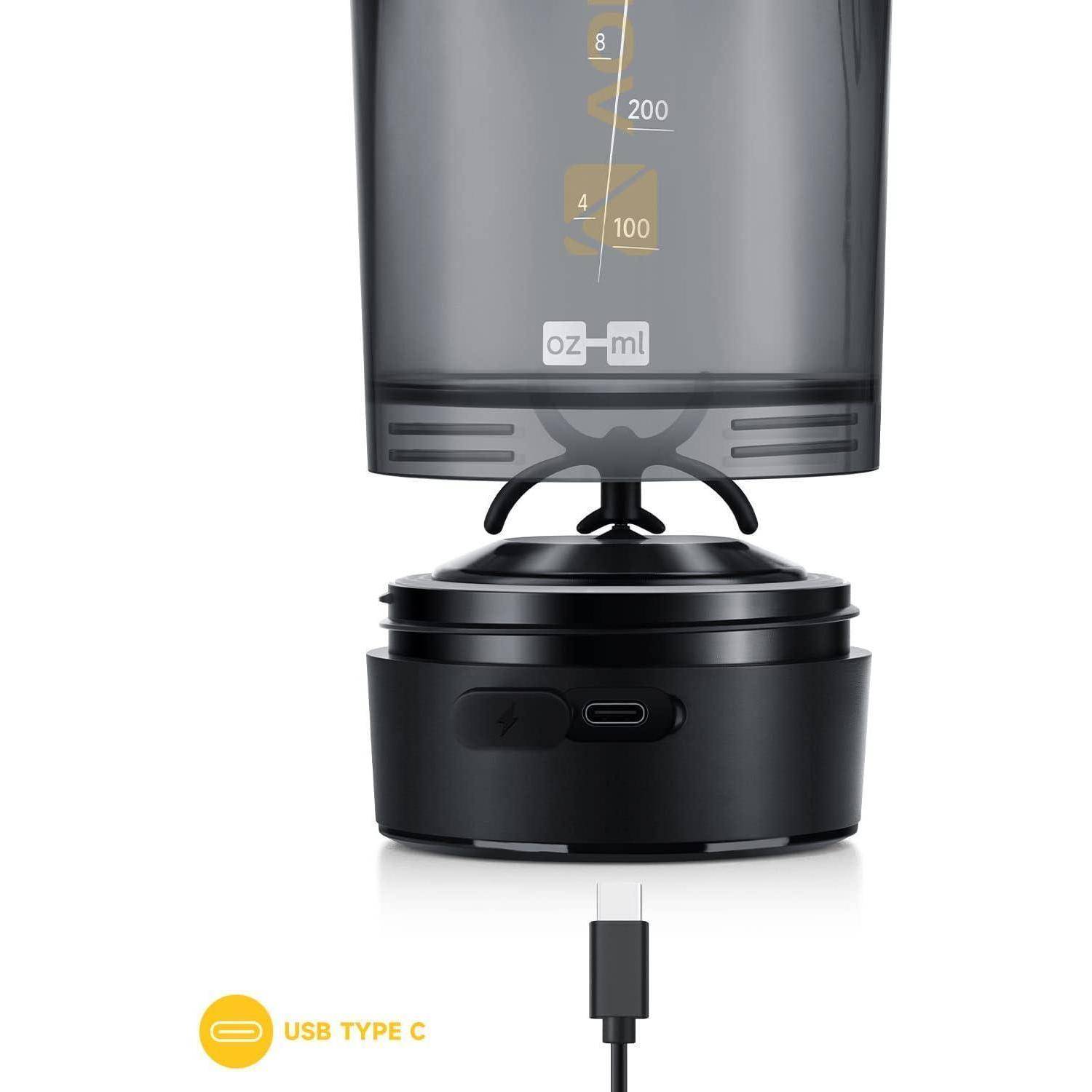 Ein Mixer mit einem durchsichtigen Becher, der Messmarkierungen zeigt. Unten eine abnehmbare schwarze Basis mit einem USB-Typ-C-Anschluss und Kabel.