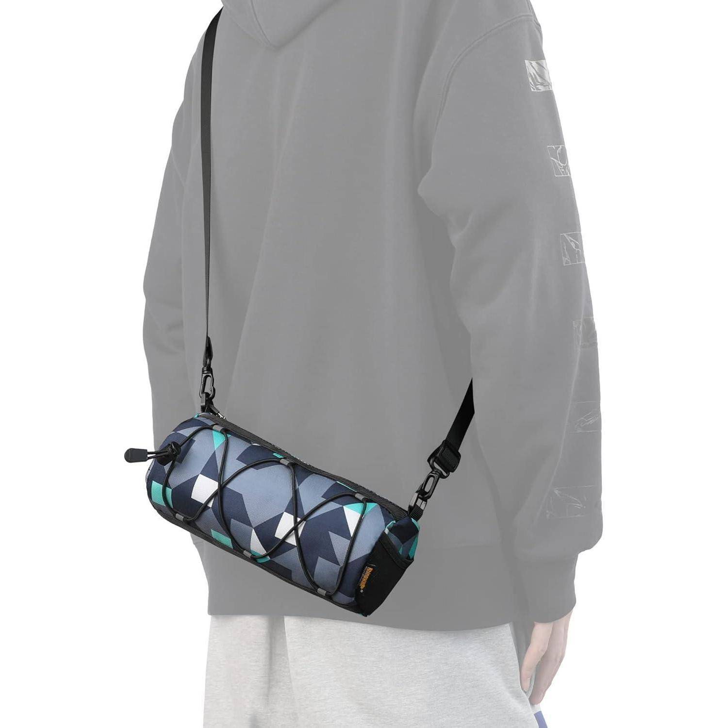 Eine Person trägt einen grauen Anzug und hat eine kleine Schultertasche mit geometrischem Muster in Blau und Schwarz.