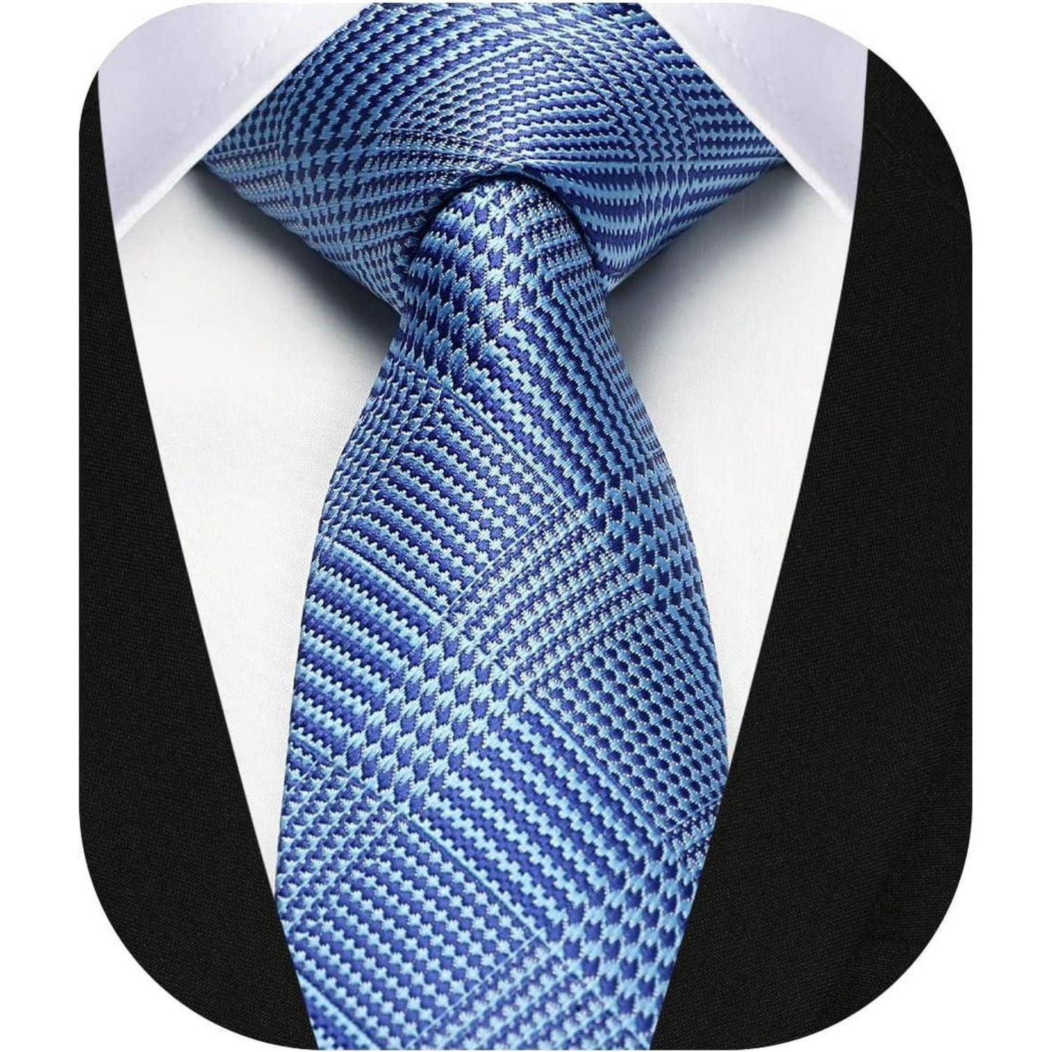 Ein Nahaufnahme einer blauen gemusterten Krawatte mit einem Knoten, getragen über einem weißen Hemd und einer schwarzen Anzugjacke, die einen formellen Look darstellt.